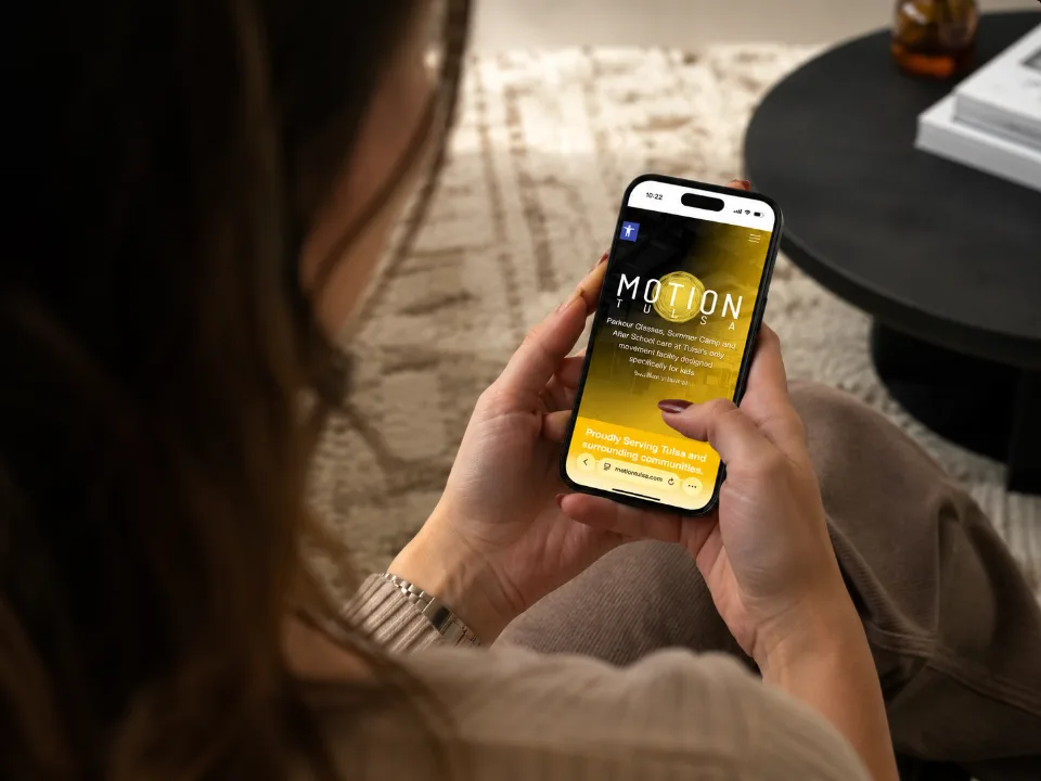 Parent browsing a martial arts school website on her smartphone, demonstrating mobile-friendly facility web design