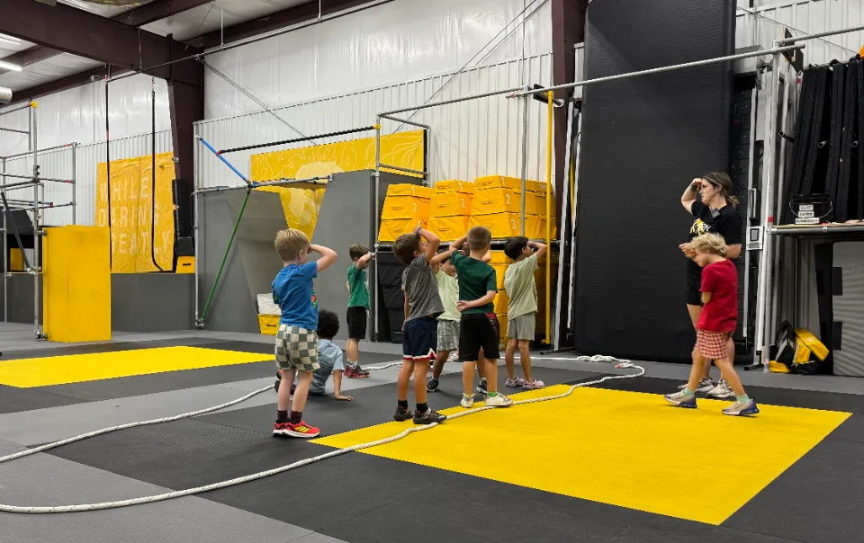 Children at a ninja gym training session with an instructor, representing the type of movement-based facility New Member Ninja serves