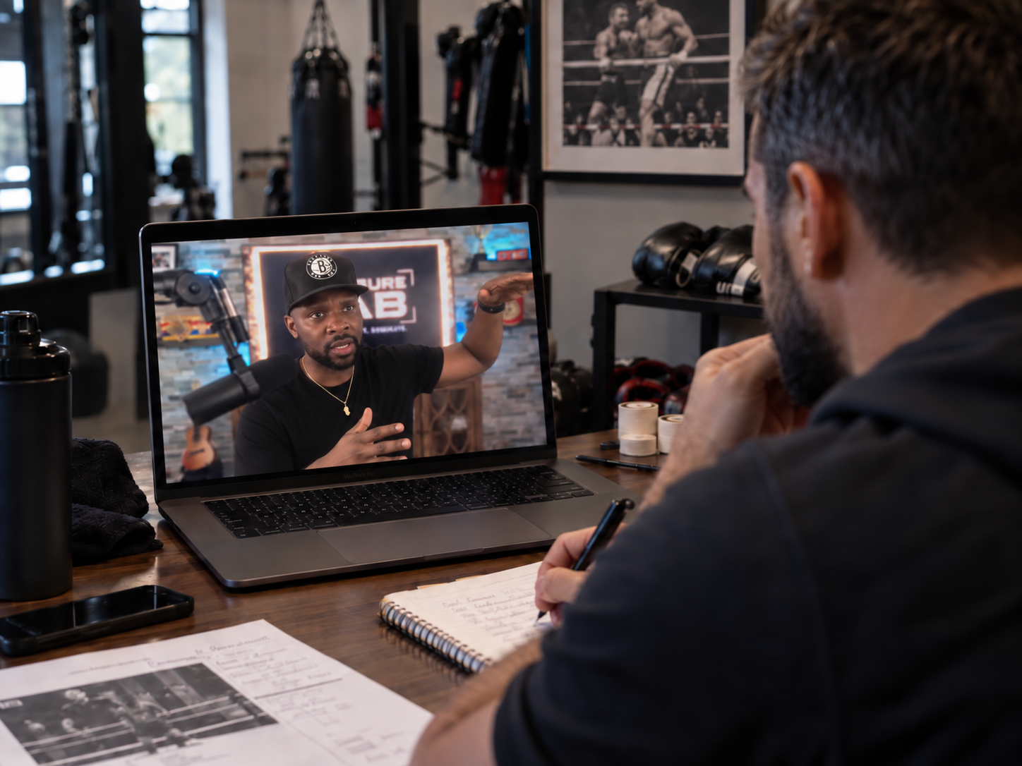 Coach taking notes during a private Zoom implementation session with Coach Eric Bradley on laptop screen
