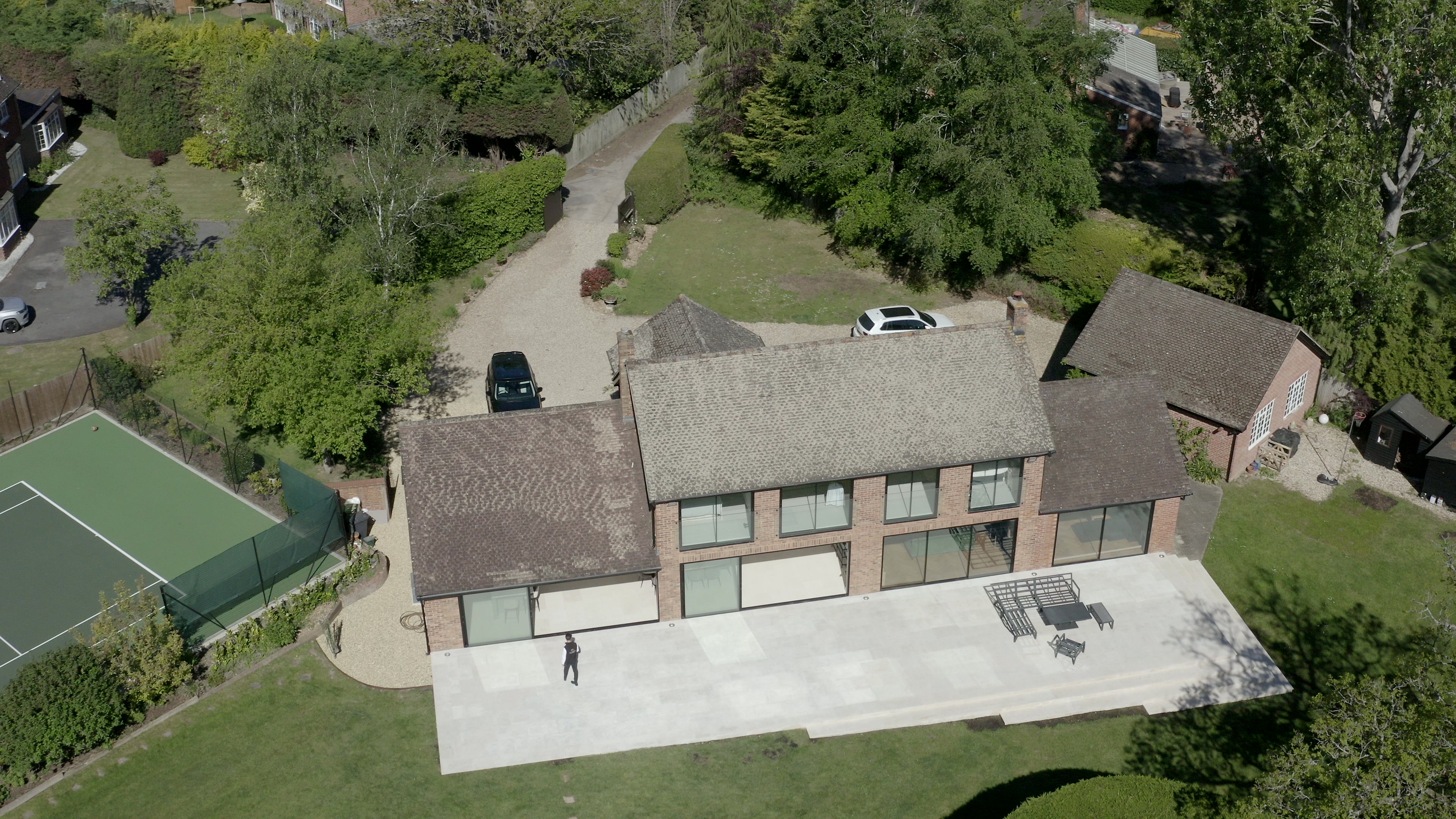 Rear aerial view of completed two storey Surrey house extension with a stone terrace