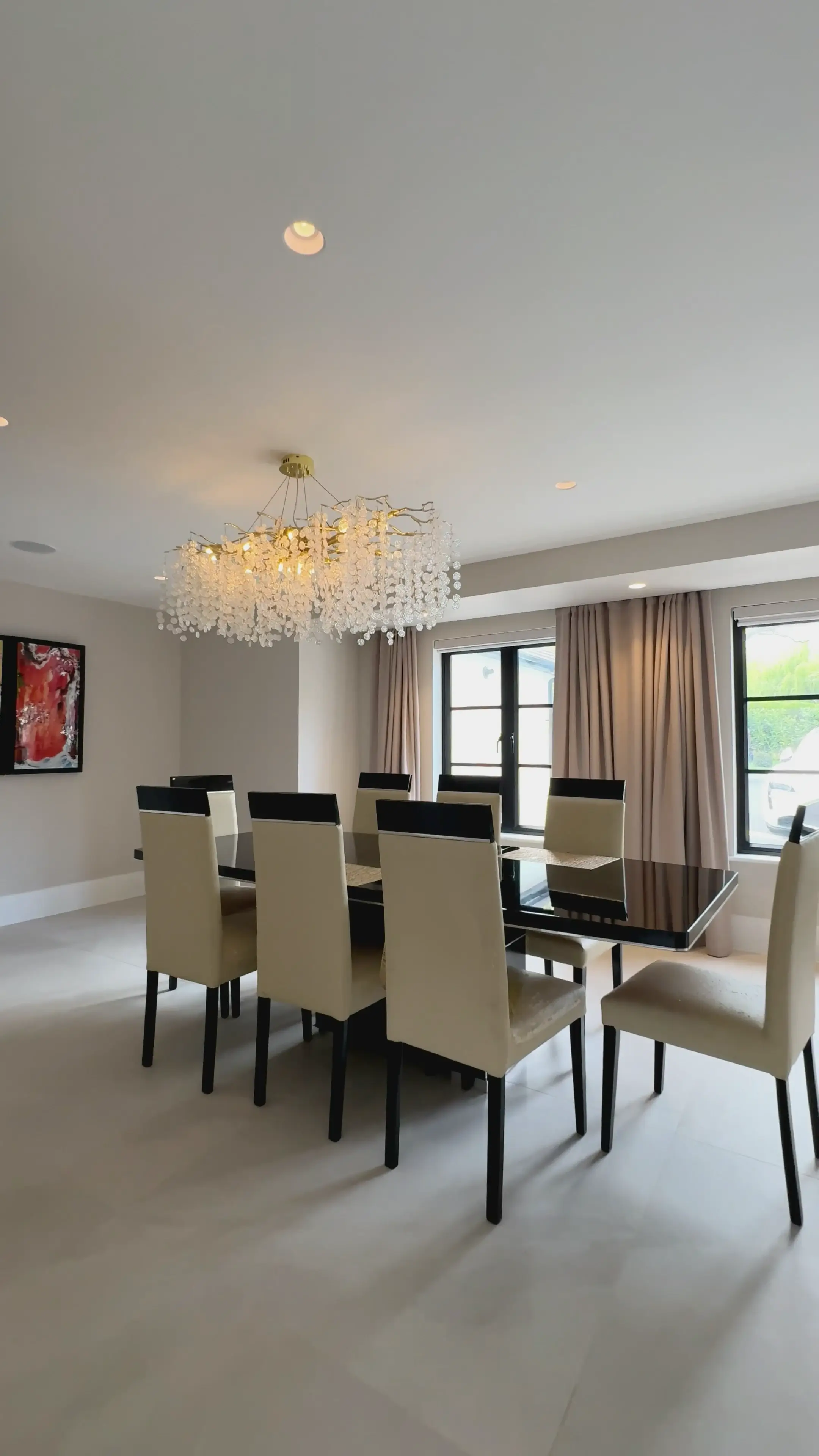 Finished formal dining room with statement chandelier and tailored drapery