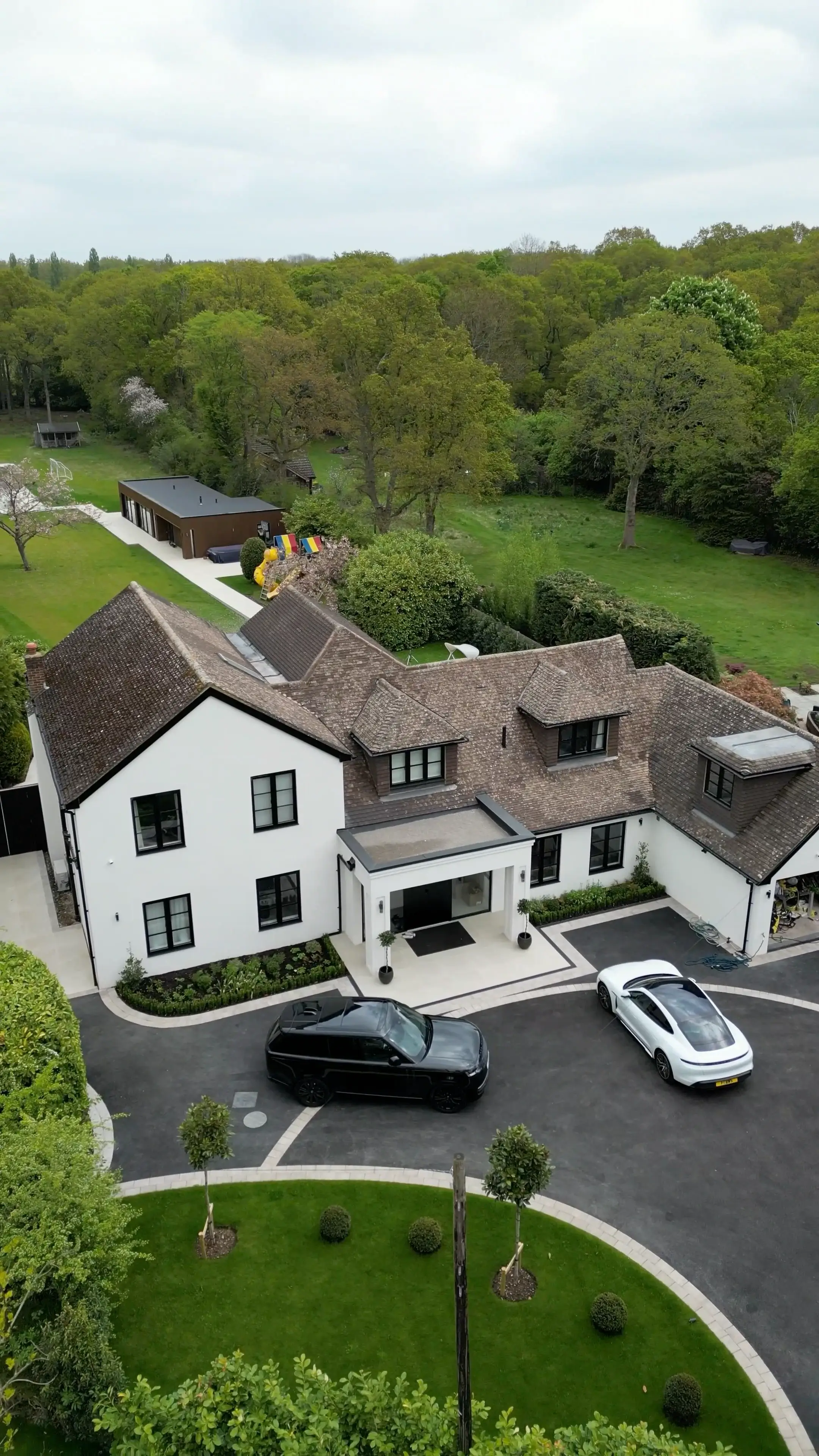 Aerial view of a substantial completed Surrey residence with a landscaped driveway