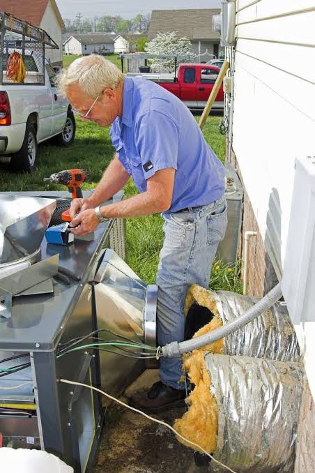 My Pearland HVAC technician inspecting and servicing an outdoor air conditioning unit