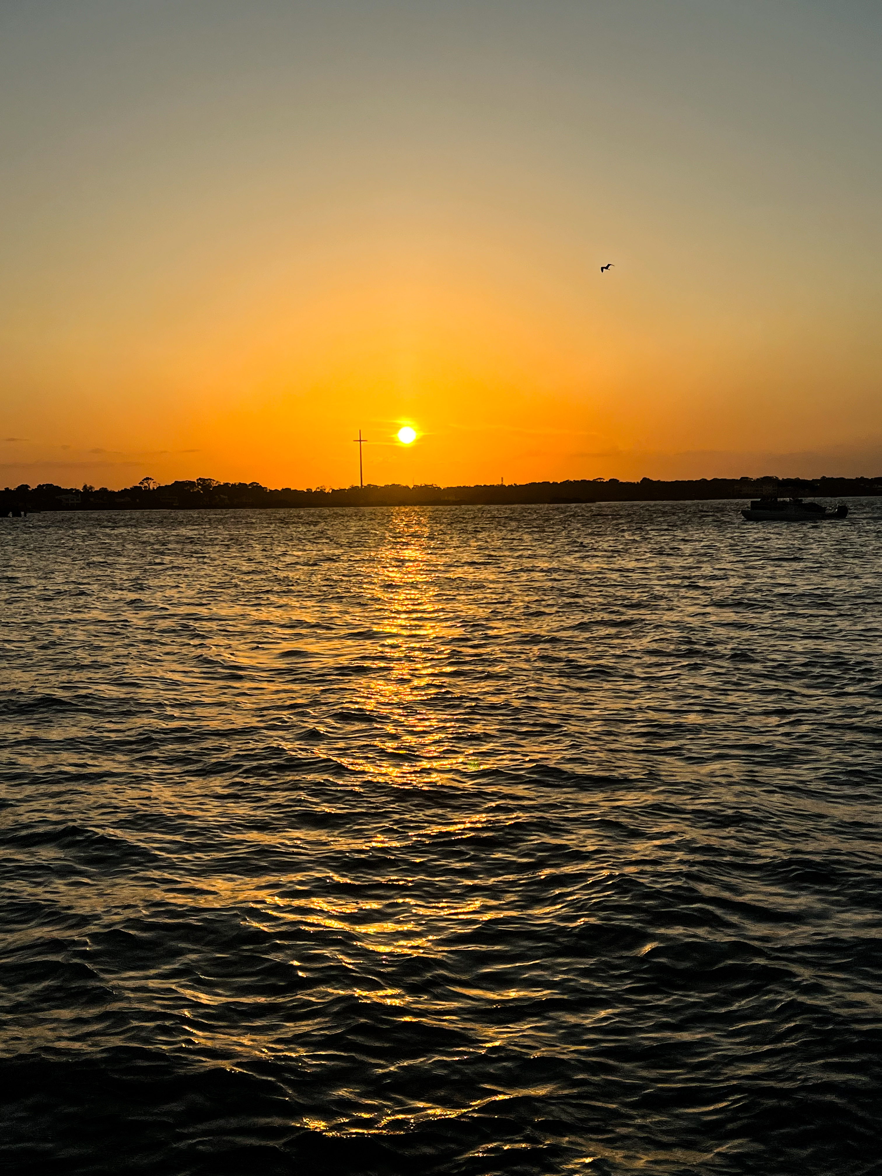 St. Augustine coastal waters and golden sunset horizon with the historic Great Cross