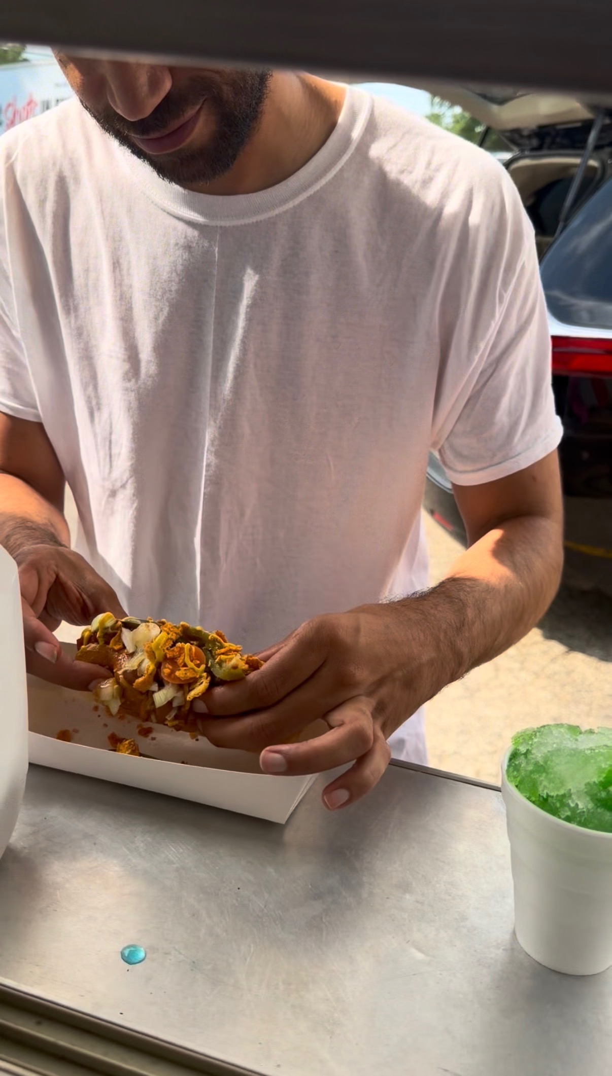 Customer loading up a hot dog with toppings at the Papa Dogs stand