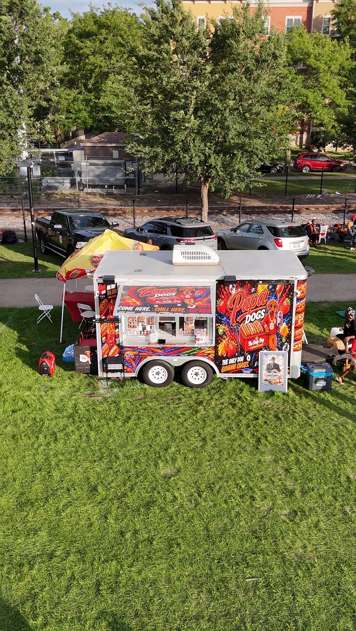 Aerial view of the Papa Dogs trailer parked at a park with the Come Here Chill Here Eat Here mural