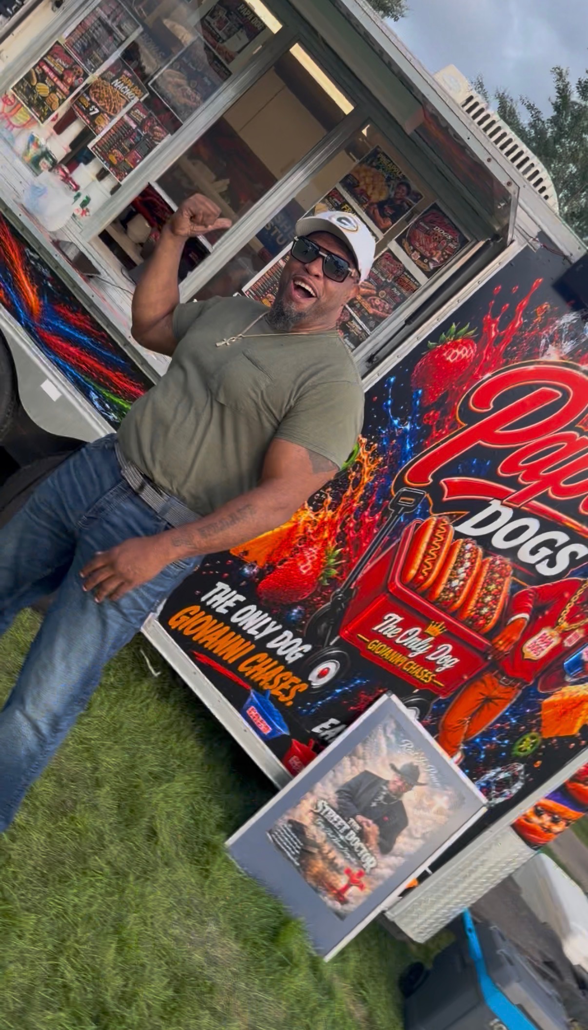 Papa Dogs team member in sunglasses smiling and flexing at the trailer window