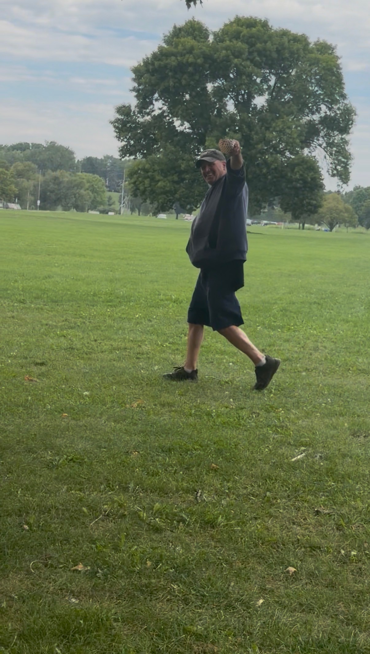 Customer holding up a Papa Dogs hot dog with pride in the park