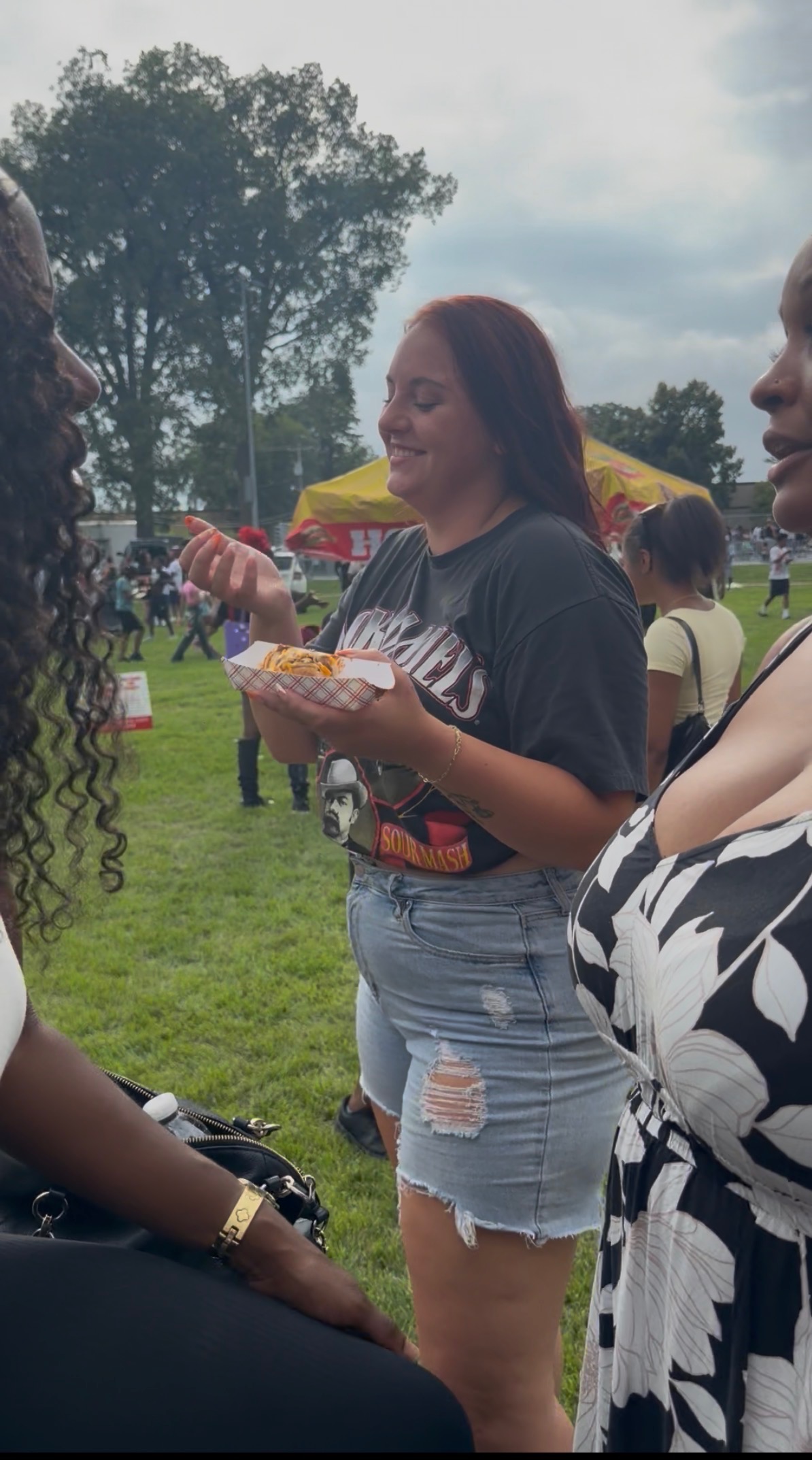 Customer smiling while holding a Papa Dogs order at an outdoor festival