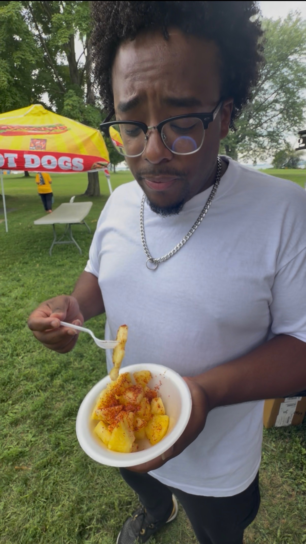 Guest enjoying fresh seasoned pineapple fruit bowl at outdoor event