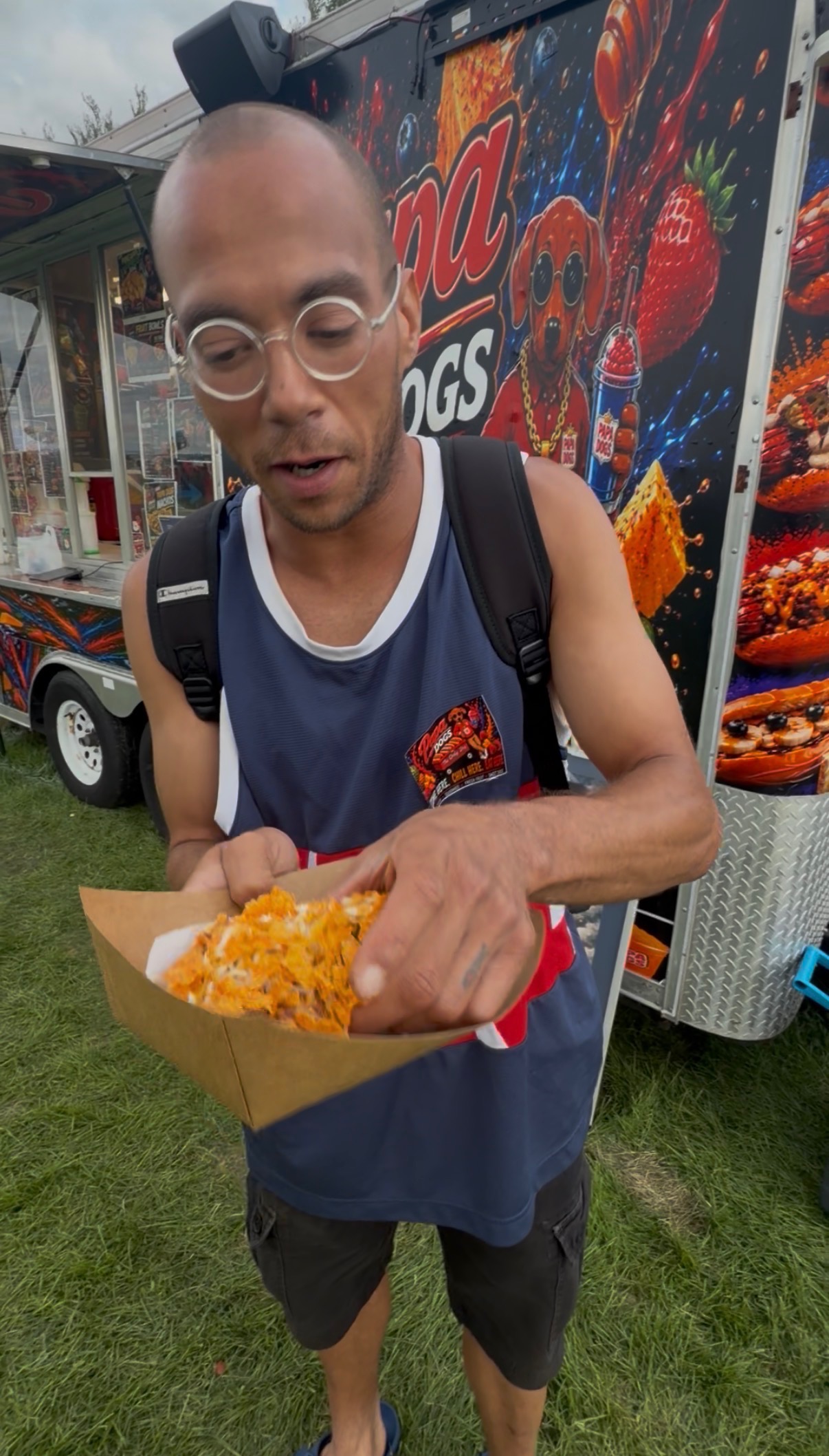 Happy customer in Papa Dogs jersey showing off his loaded hot dog in a basket