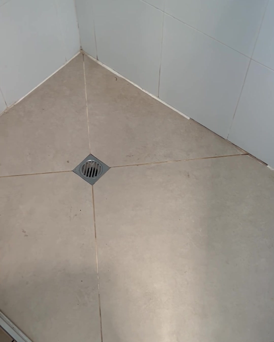 Shower wall before restoration, discoloured grout, mould patches and degraded silicone corner joins
