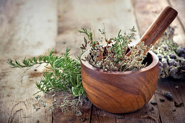 Mortar and pestle with fresh medicinal herbs used to prepare naturopathic remedies