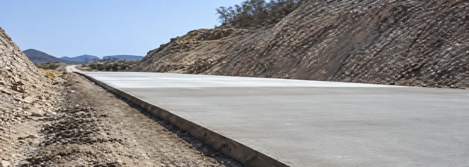 Tramo de calzada terminado con losa de concreto rígido y estabilización de taludes a lo largo del corredor de acceso