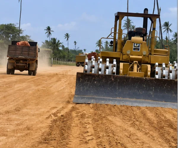 Conformación masiva de terraplén vial: tractor compactador Caterpillar de pata de cabra y flota de camiones volteo en descarga de material granular