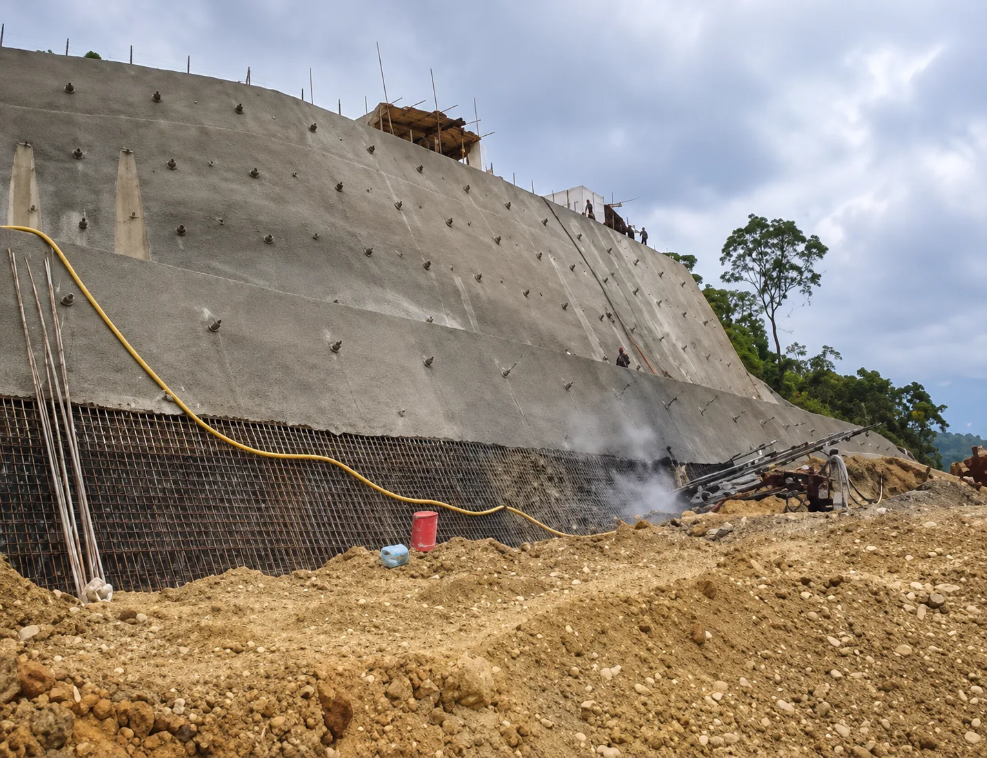 Estabilización geotécnica de ladera: pantalla anclada de concreto lanzado (shotcrete) y bulones activos de sostenimiento en talud de corte