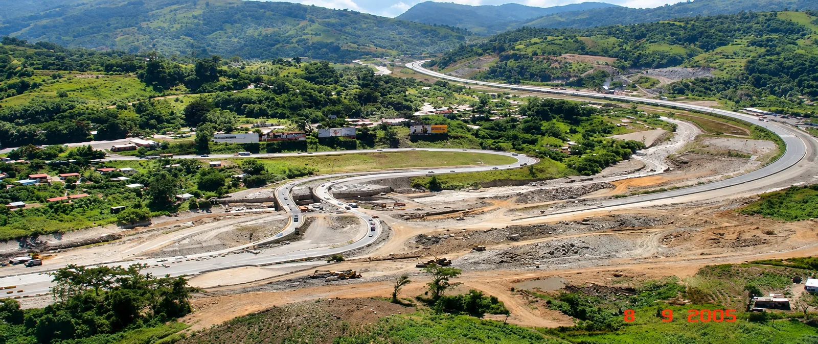 Panorámica aérea del Distribuidor vial, ramales de enlace, encauzamiento fluvial del Río Grande y trazado completo en el valle (Registro en obra: septiembre 2005)