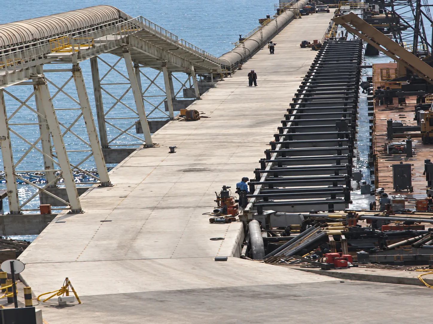 Tablero del puente de acceso en reparación con estructura de vigas prefabricadas, sistema de transporte de graneles y muelle temporal de apoyo