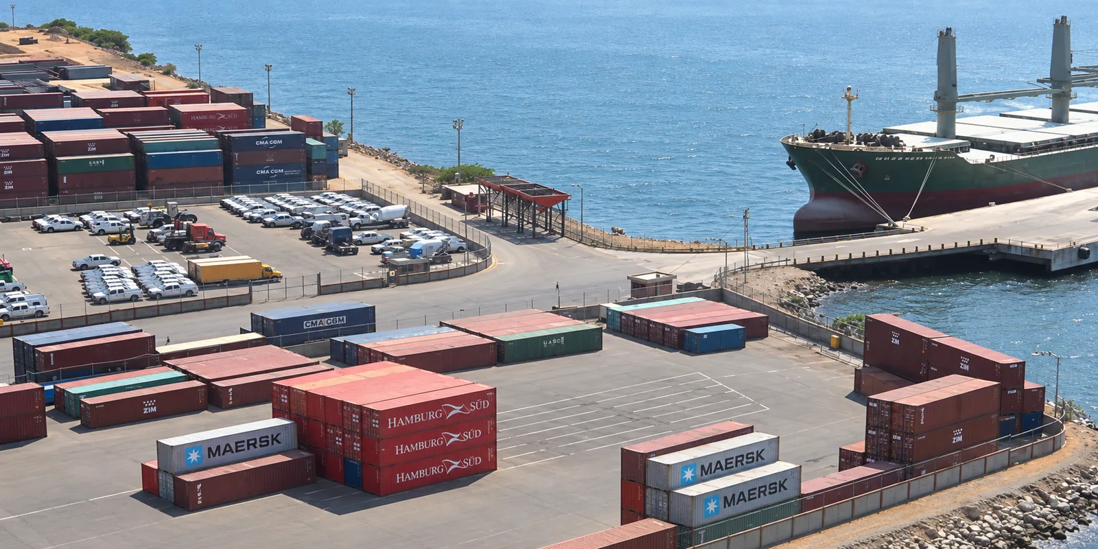 Patio intermodal de contenedores, maniobras de carga y buque portacontenedores en operaciones simultáneas