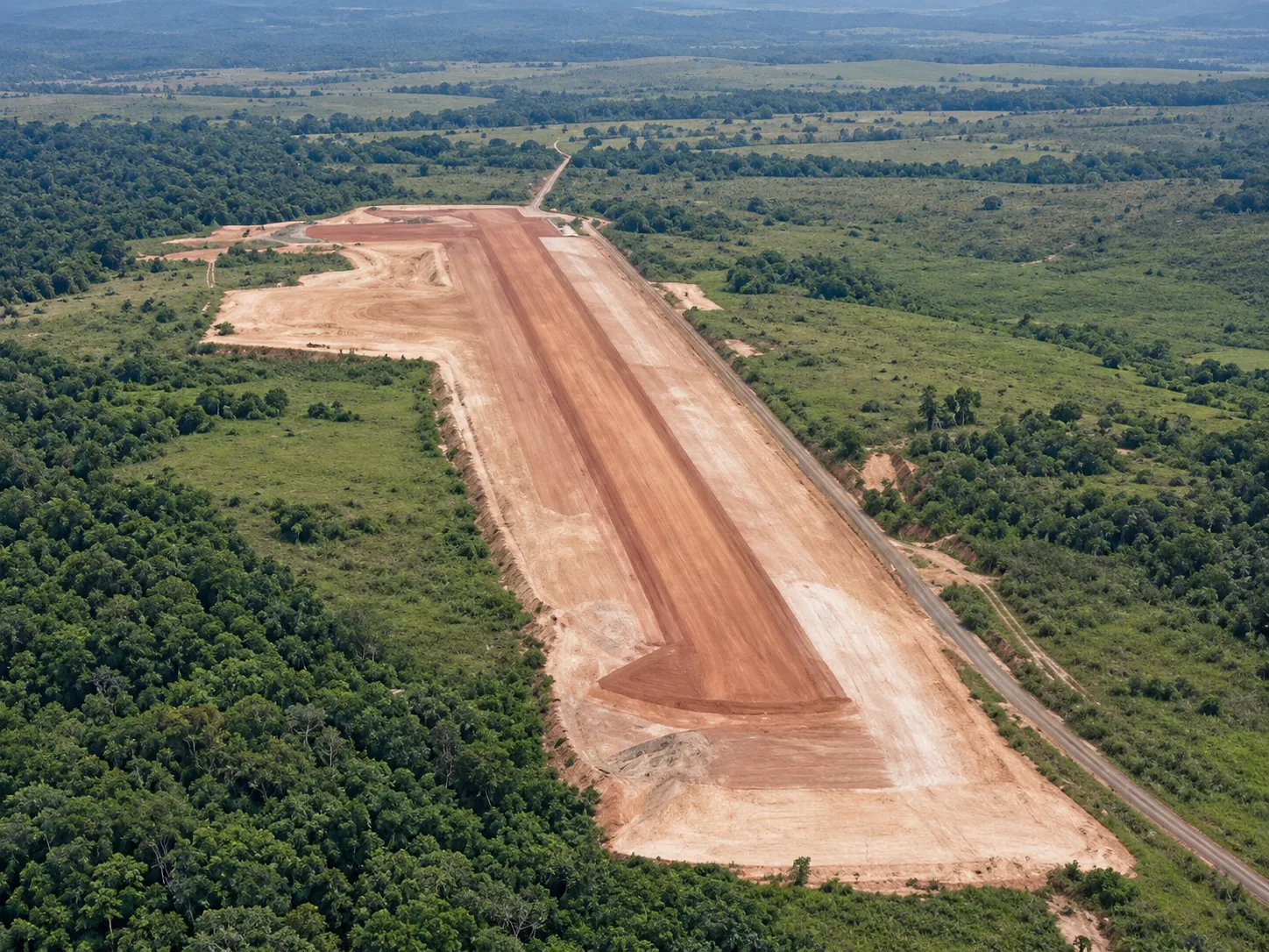 Panorámica aérea de conformación y compactación de la subrasante: alineación longitudinal completa de 1.650 metros, terraceo lateral y acondicionamiento del área de plataforma y rodaje