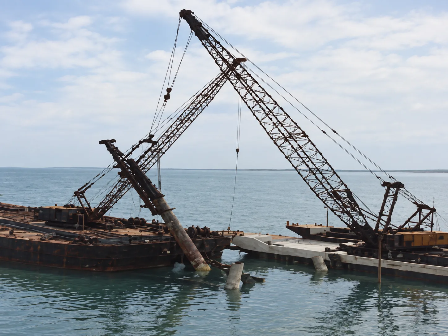 Maniobras marítimas de hincado e inclinación de pilotes de acero con pontón flotante y grúas de celosía bajo condiciones de mar abierto