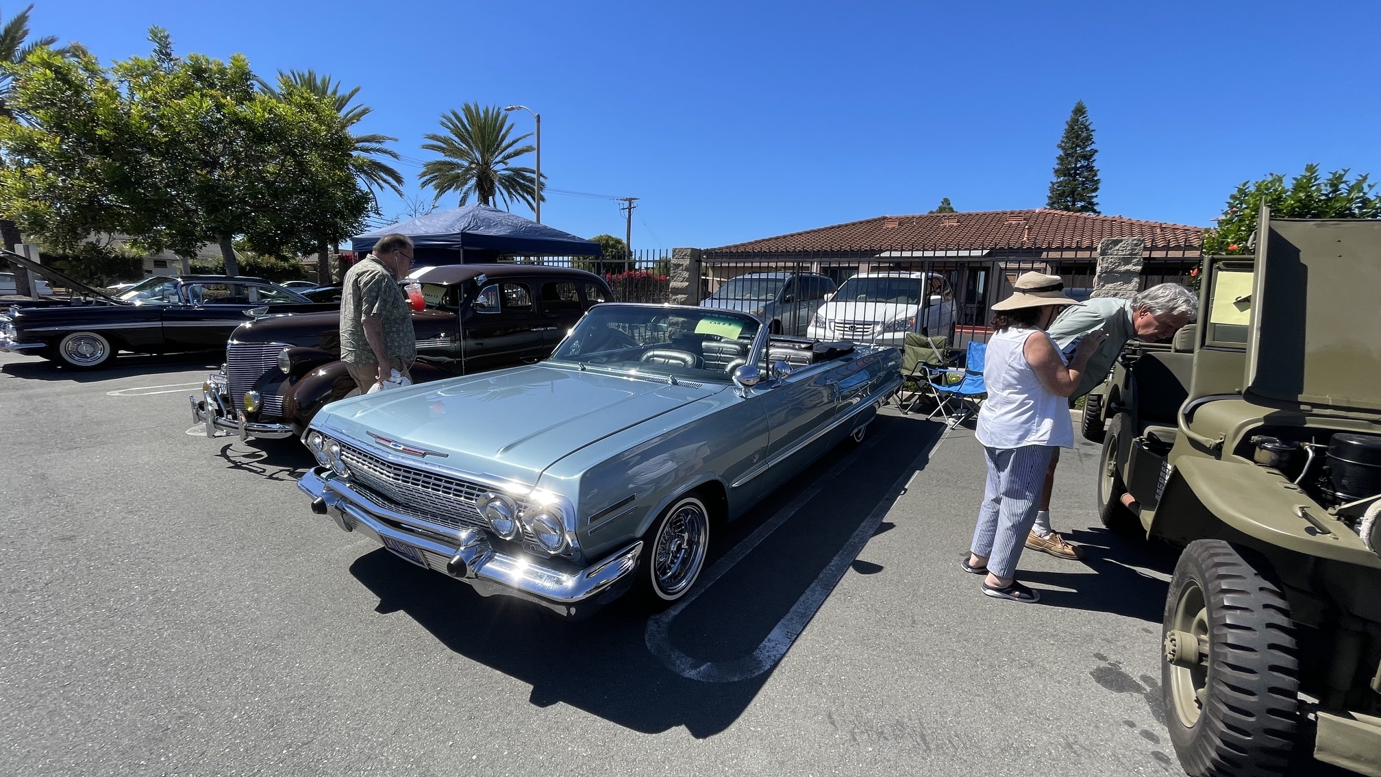 Powder blue classic Chevrolet convertible cruiser and vintage military vehicle at the parish car show