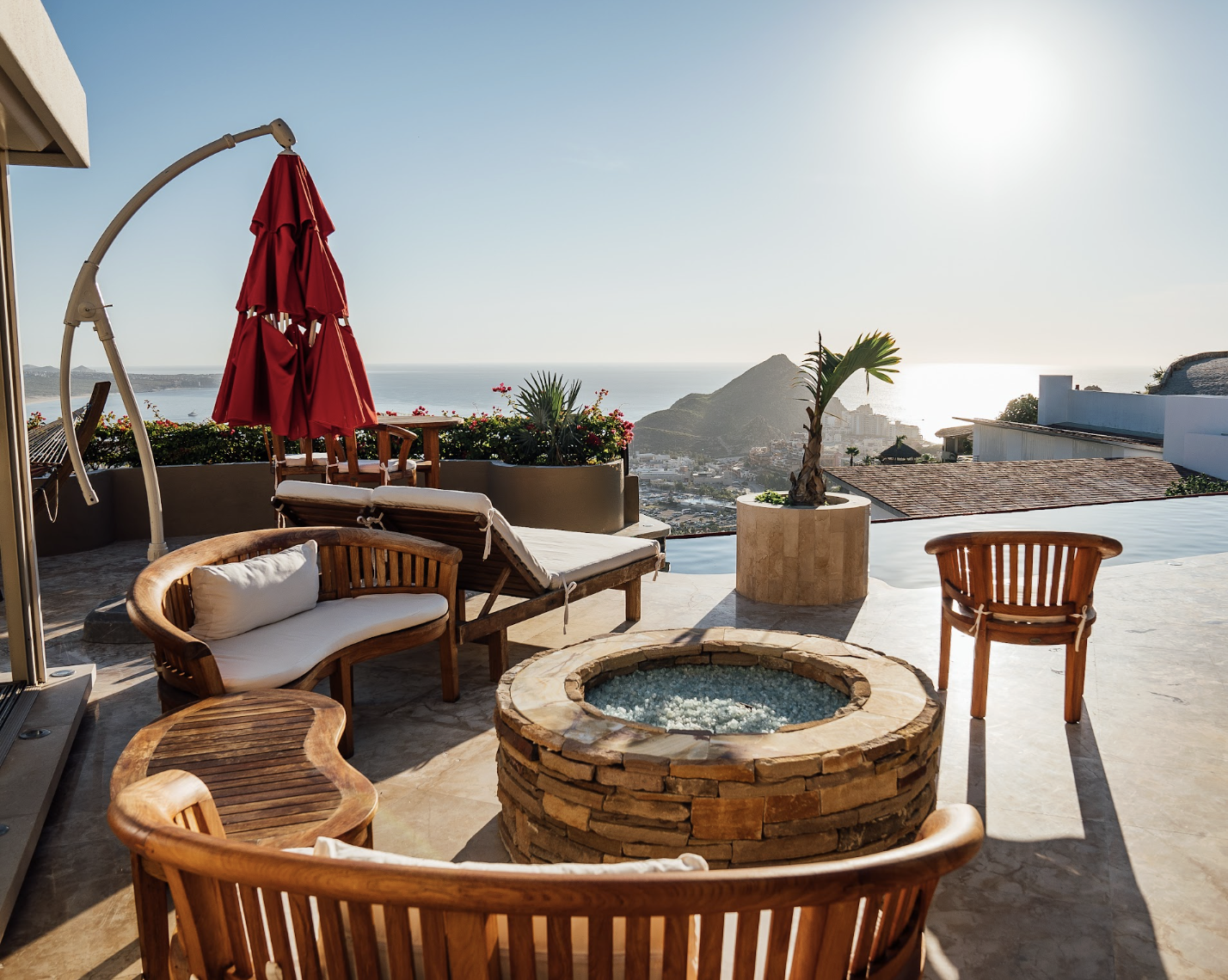 Outdoor living and stone fire pit overlooking the sea