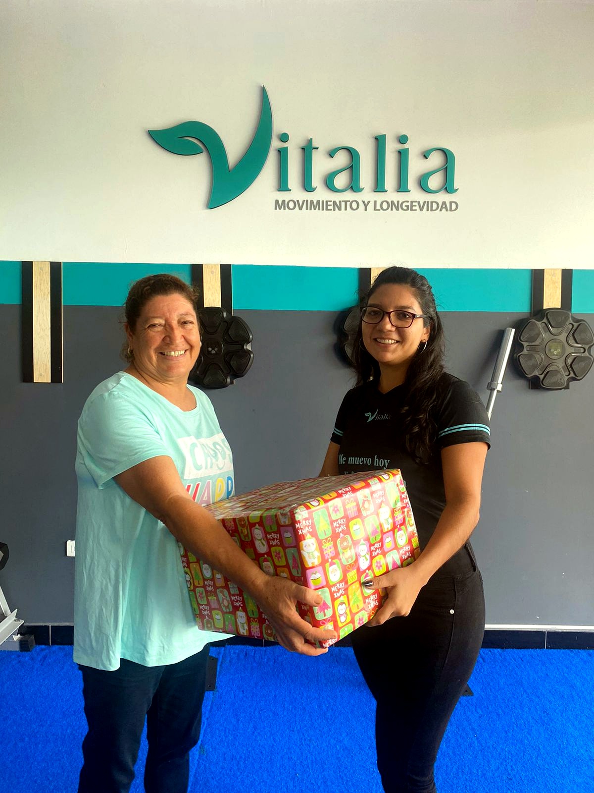 Miembro y entrenadora celebrando con obsequio en Vitalia Club