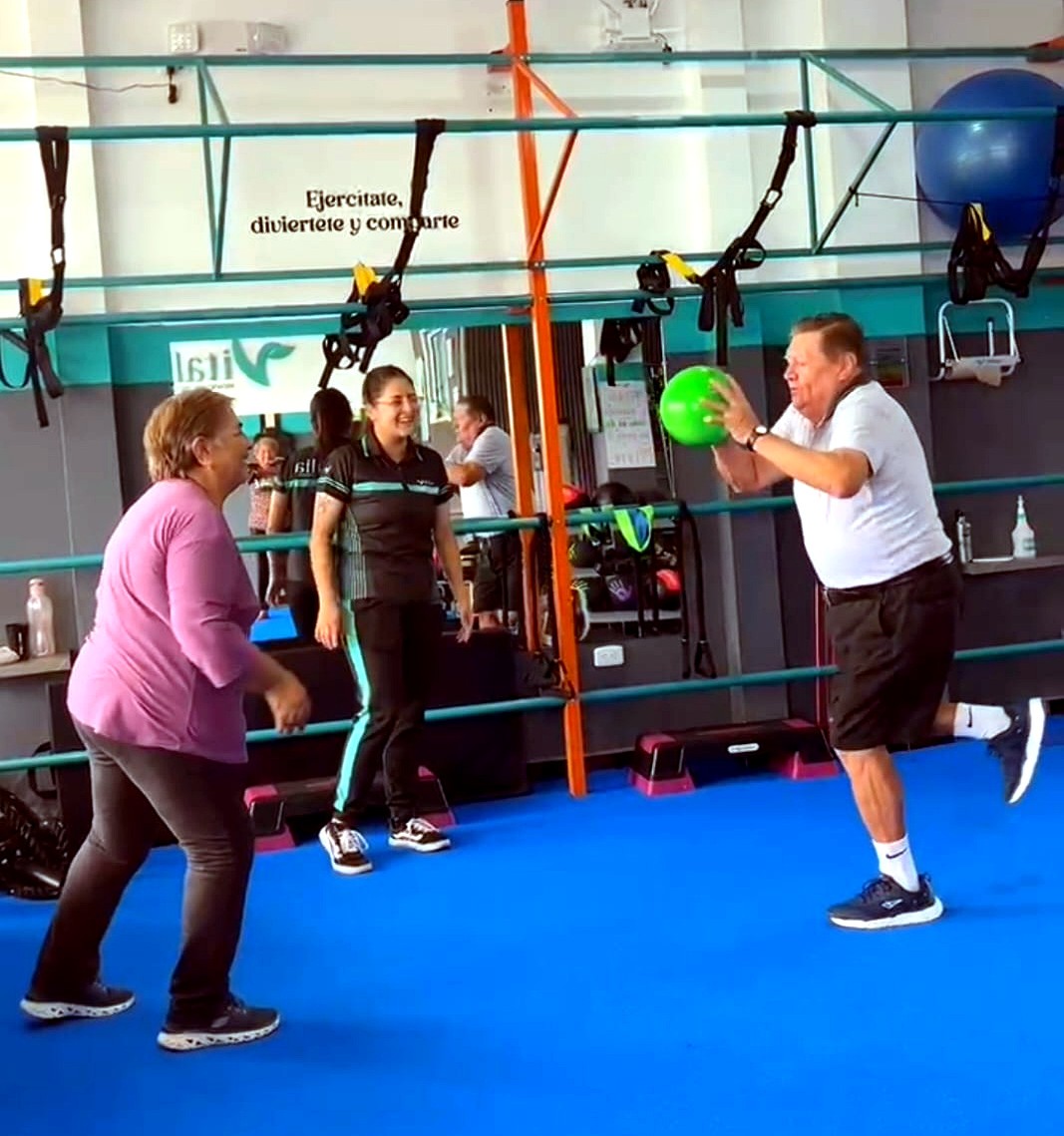 Miembros de Vitalia Club entrenando equilibrio y coordinación con balón medicinal junto a su entrenadora