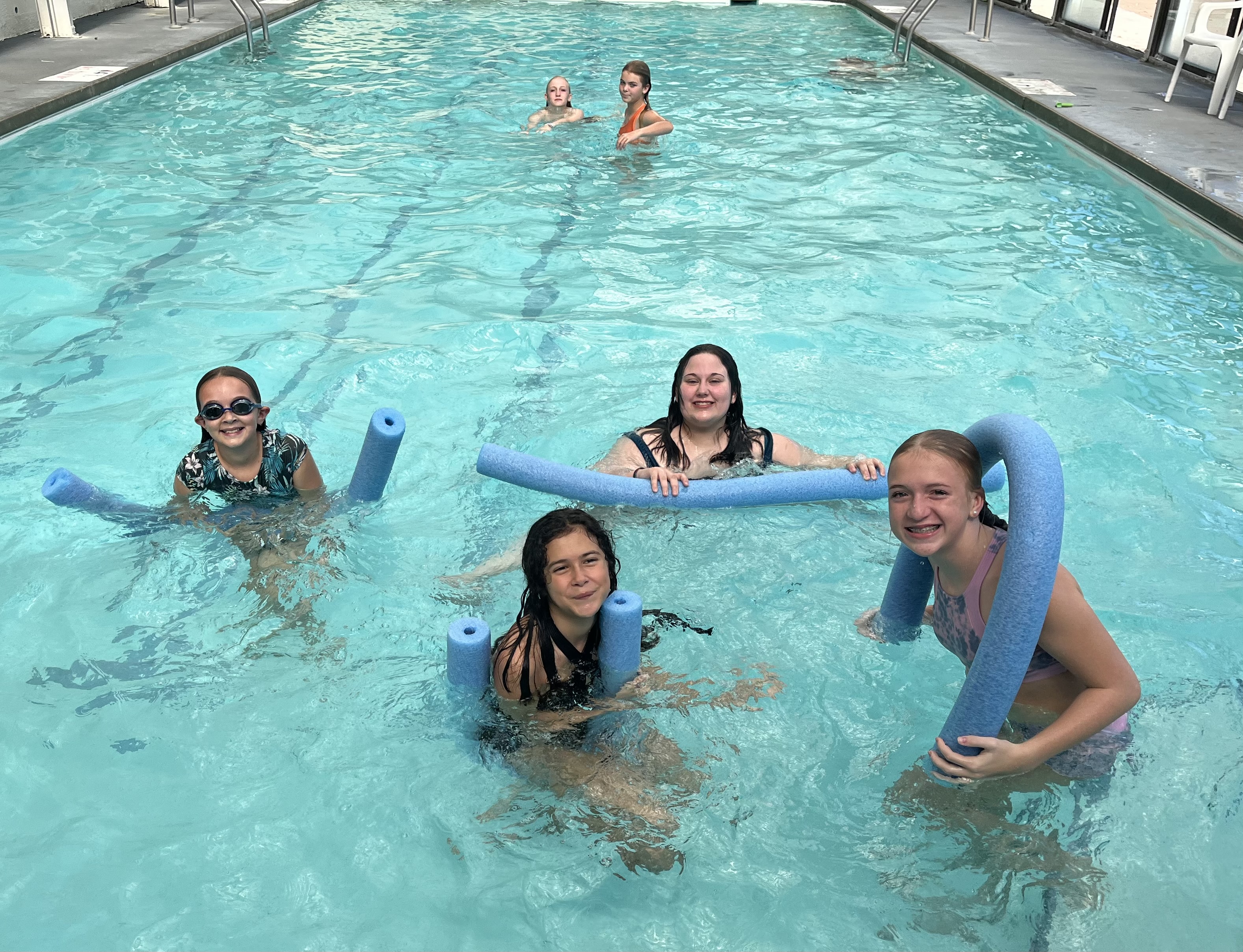 Kids celebrating and swimming at an Olympia Athletic Club pool party