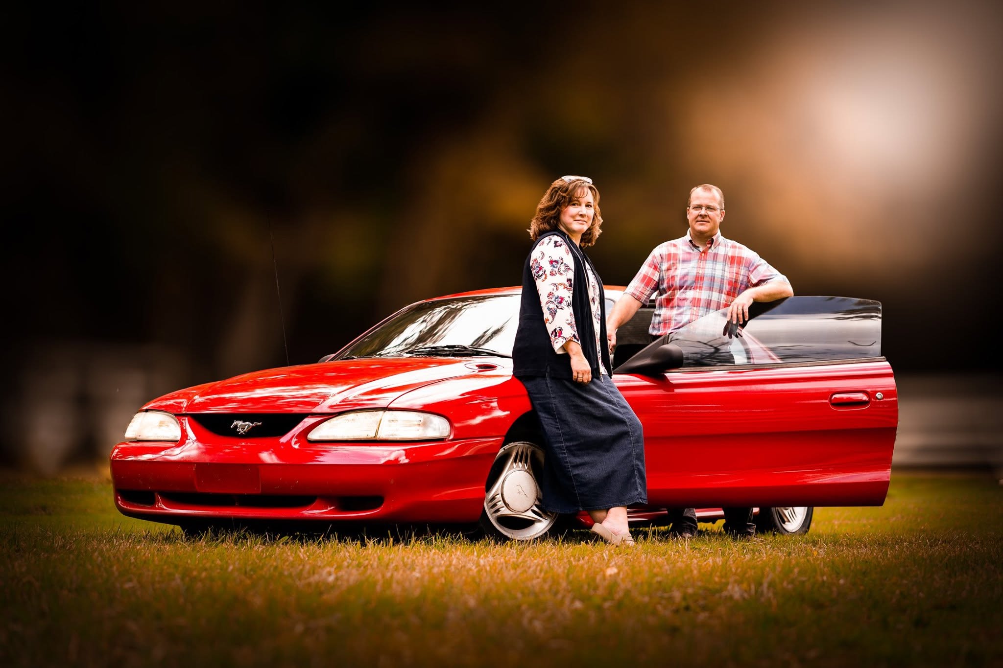 Couple portrait by red car — portfolio closing image