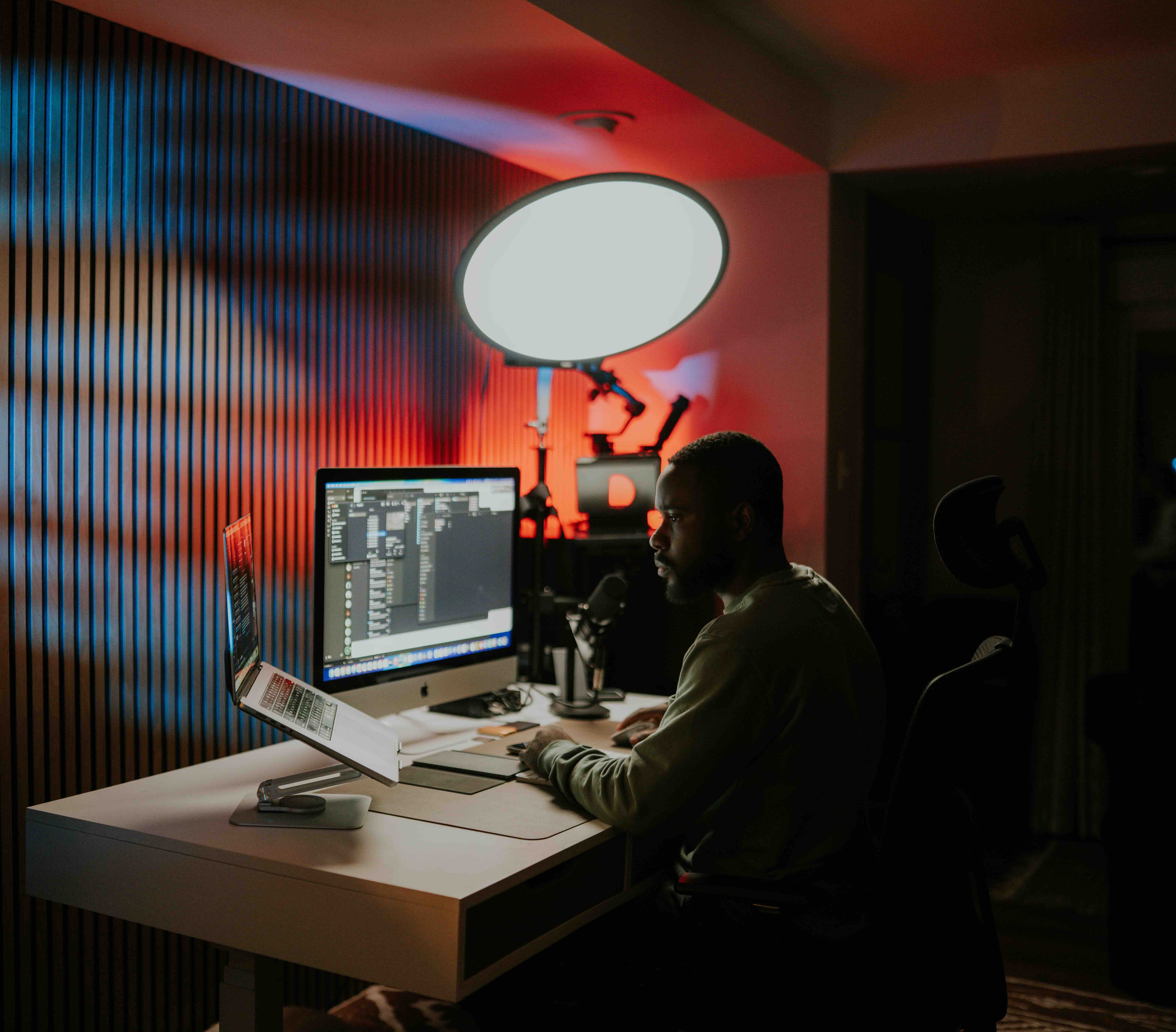 Abraham editing wedding film and photos at desk with dual monitors