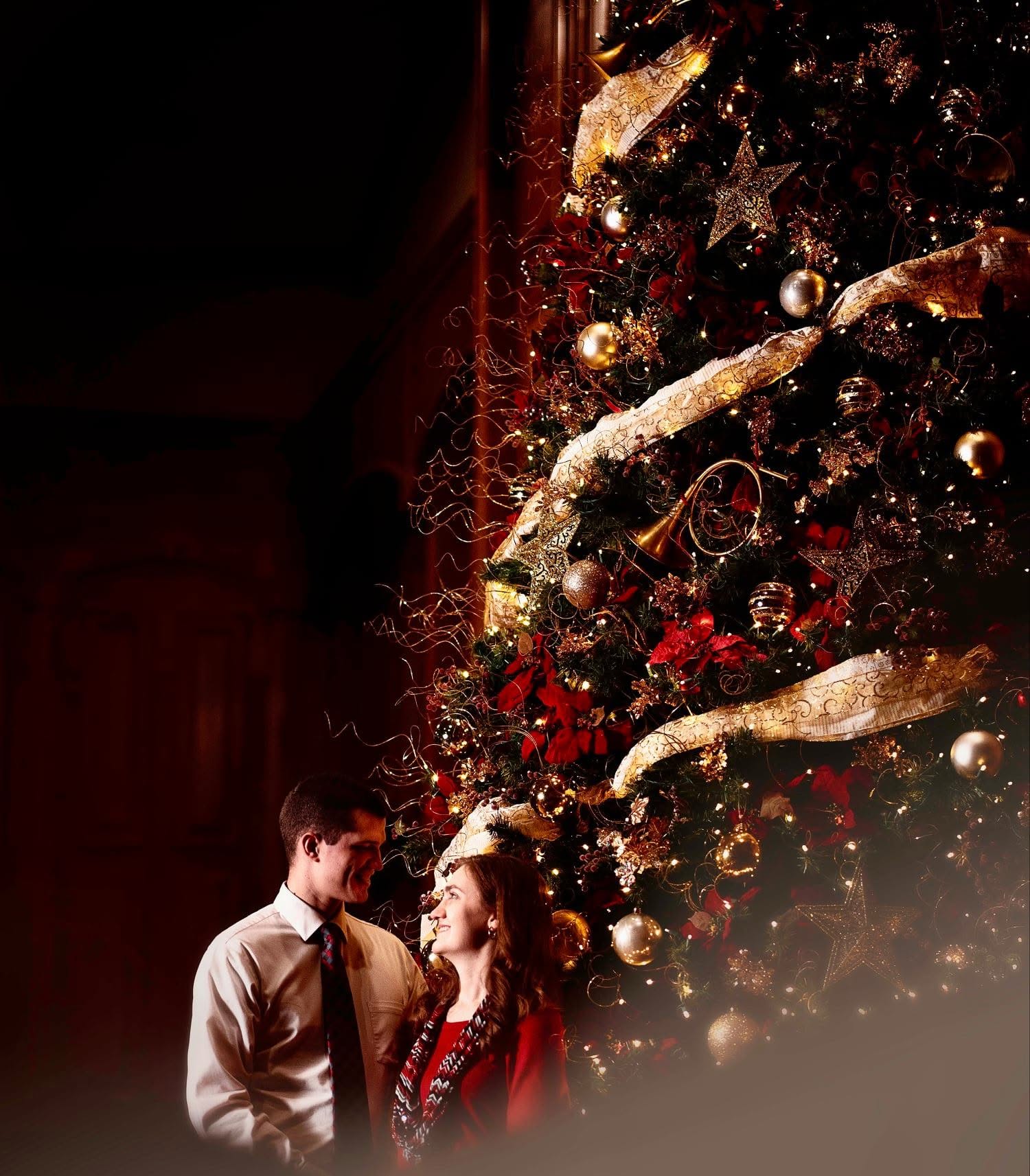 Couple in front of glowing Christmas tree