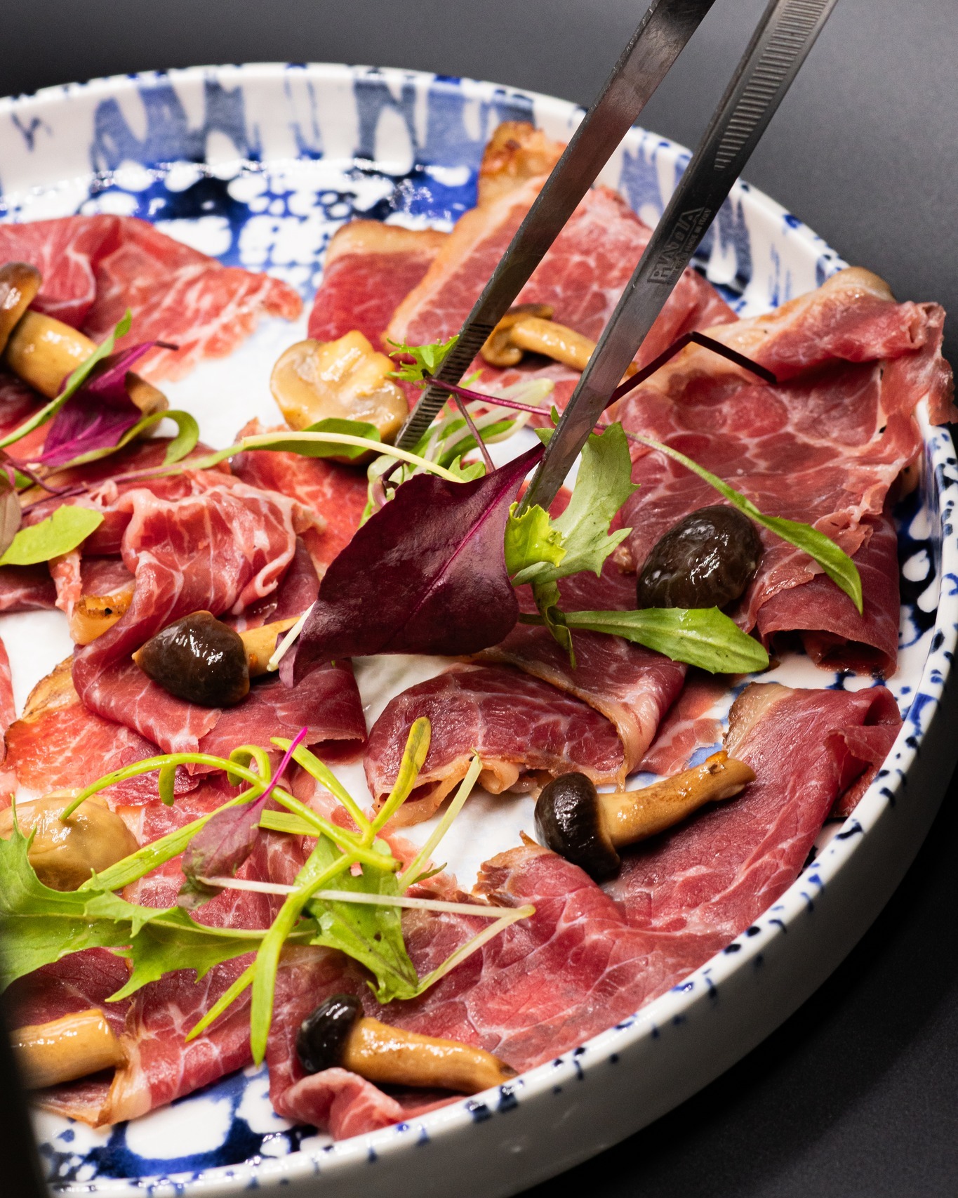 Carpaccio di manzo con funghi e germogli servito al piatto