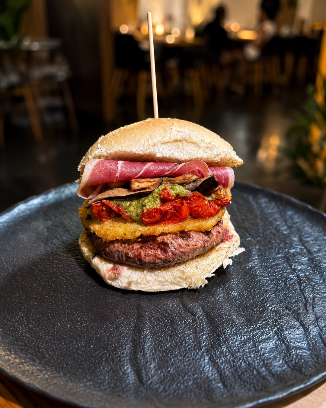 Panino gourmet con burger di carne, cotoletta e pomodorini secchi