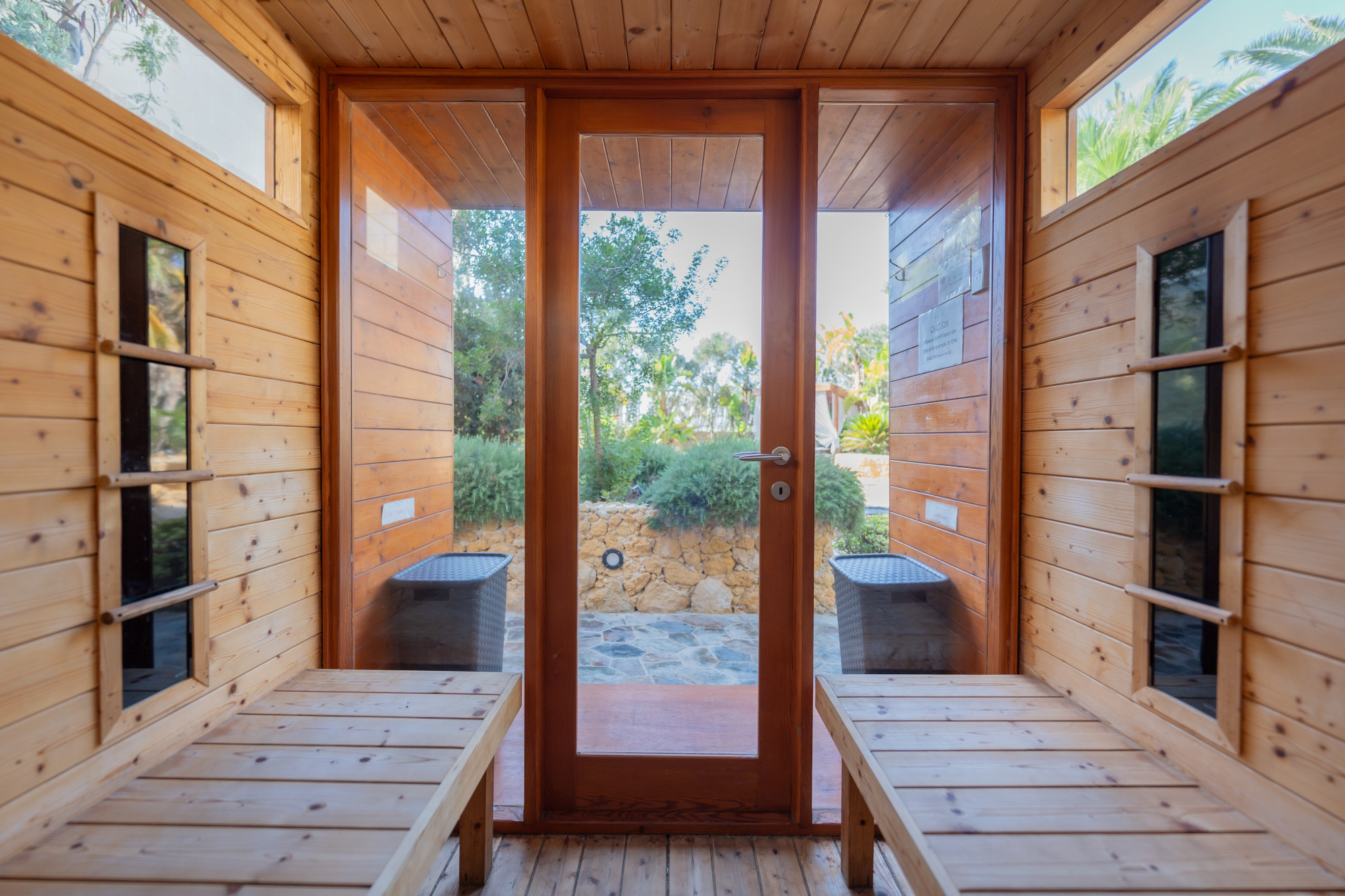 Outdoor-facing infrared sauna cabin with views over Mediterranean gardens