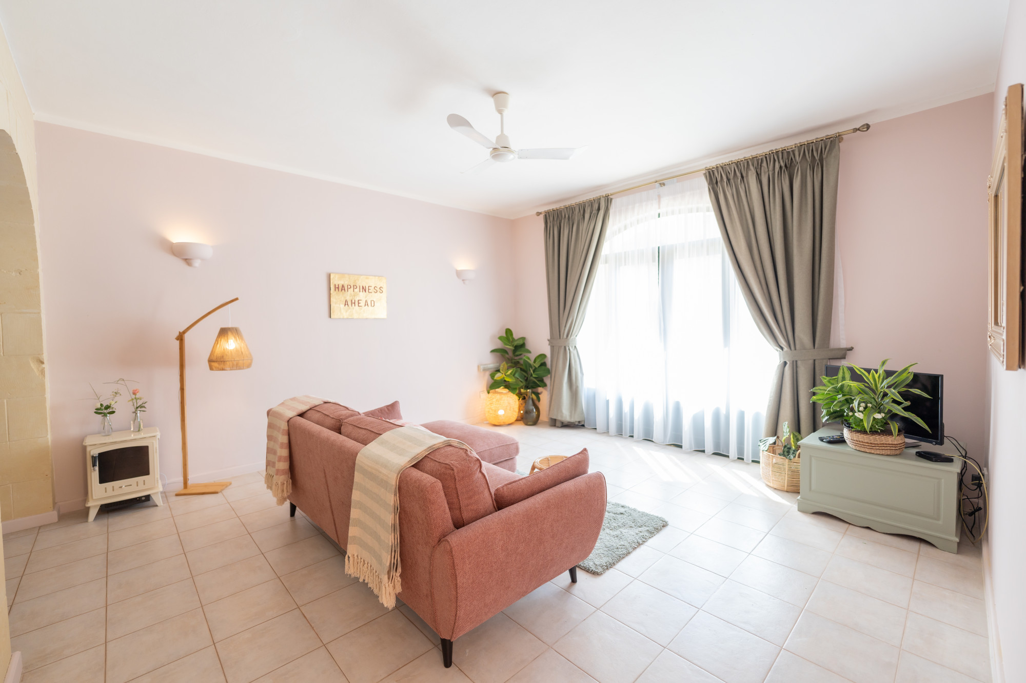 Sunlit guest apartment lounge with plush seating and warm interior styling