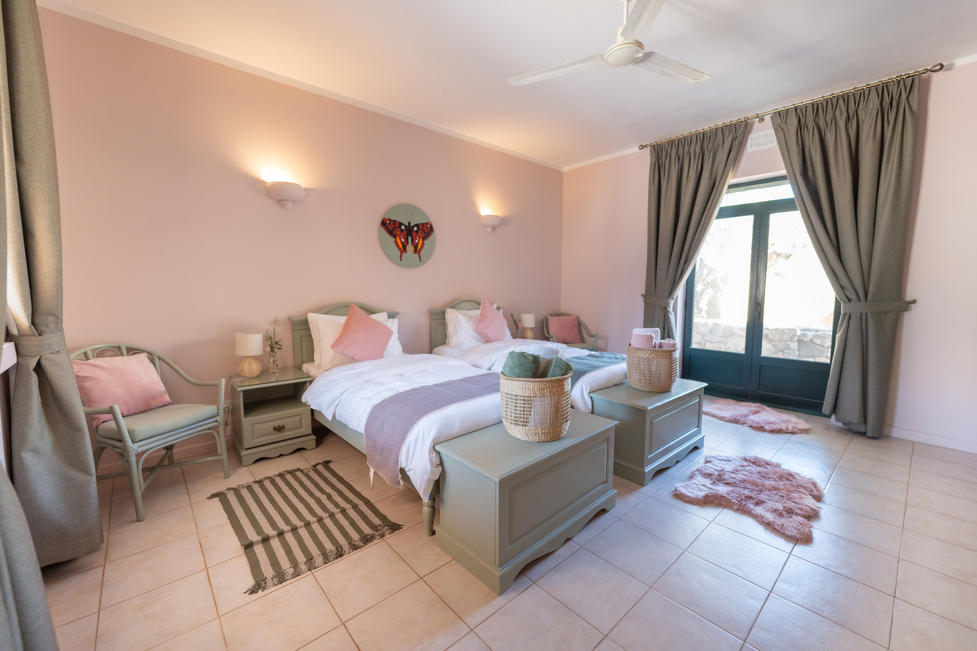 Deluxe twin bedroom with sage green decor, patio access and soft lighting