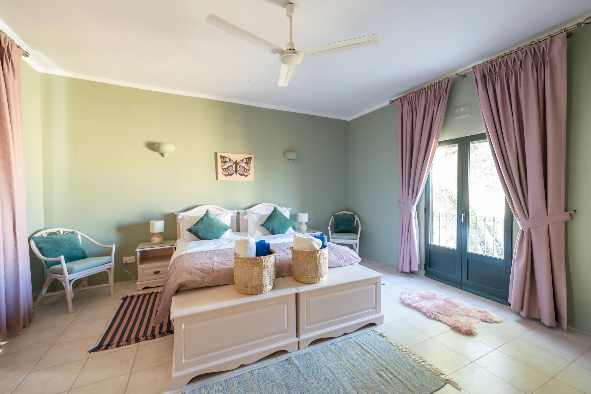 Spacious master bedroom with private balcony, soft sage tones and natural light