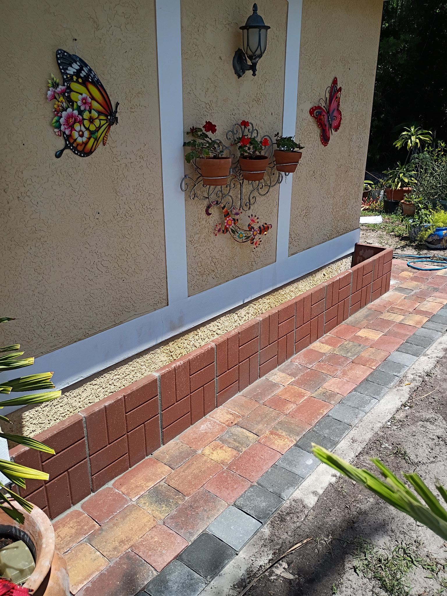 Custom brick paver walkway and raised decorative retaining bed installation completed by Bless Gardenz