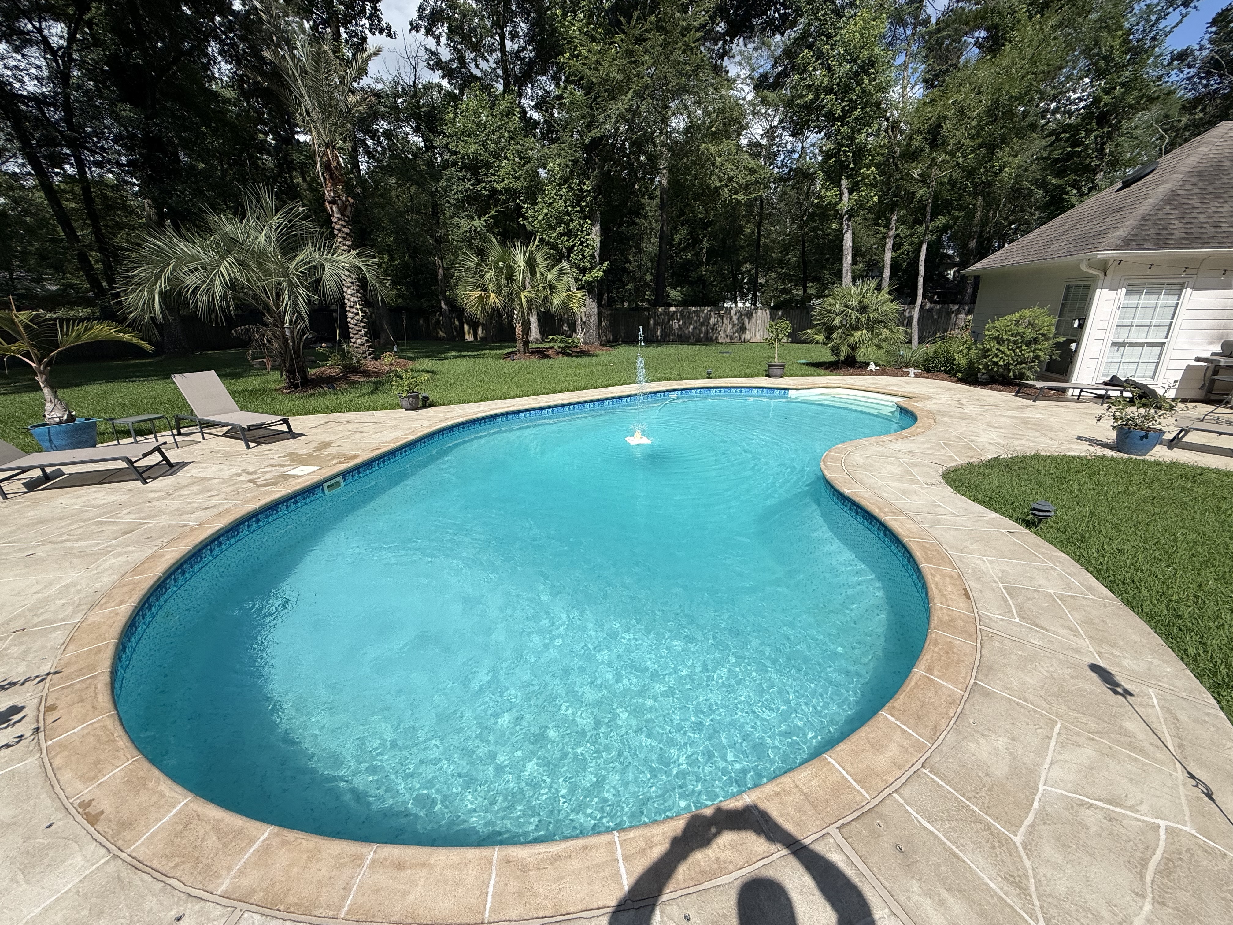 Weekly pool cleaning service in Cypress backyard swimming pool kept clear and blue