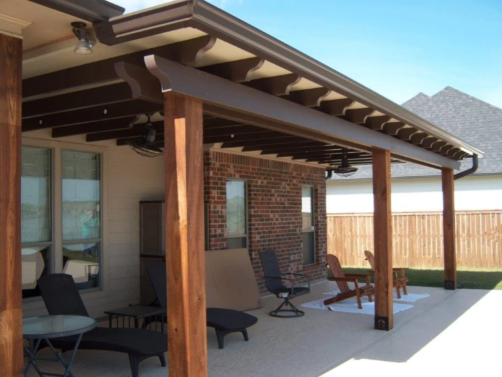 Solid patio cover with decorative cedar posts and ceiling fans