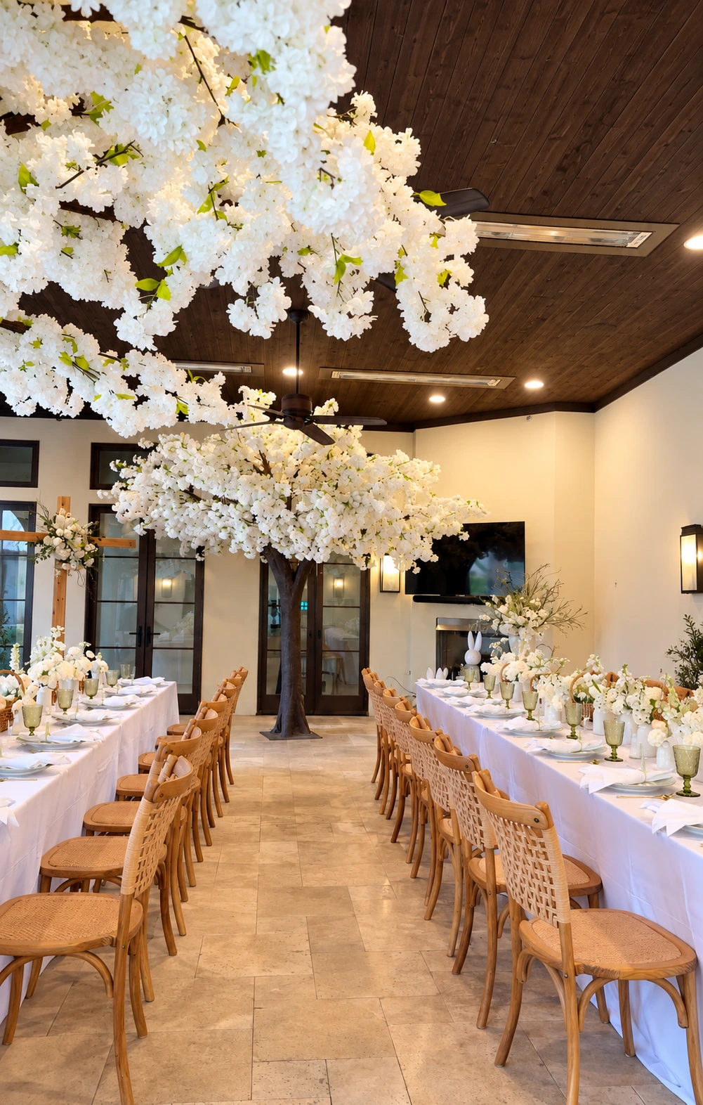 Elegant dining room celebration designed by Petit Seating featuring white blossom tree installations and styled tables