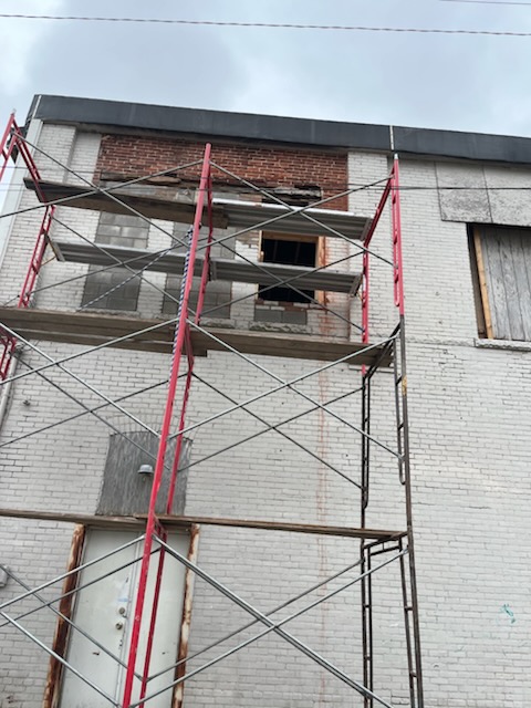 Scaffolding set against a two story masonry building during exterior restoration work in progress
