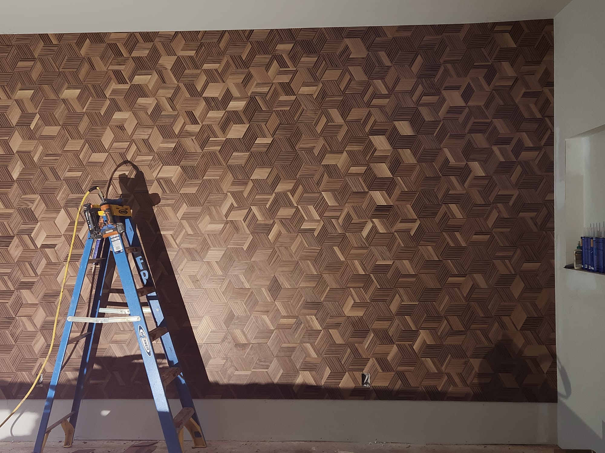 Full-wall 3D geometric isometric optical cube wood mosaic installation with finish carpenter tools in Winston-Salem NC