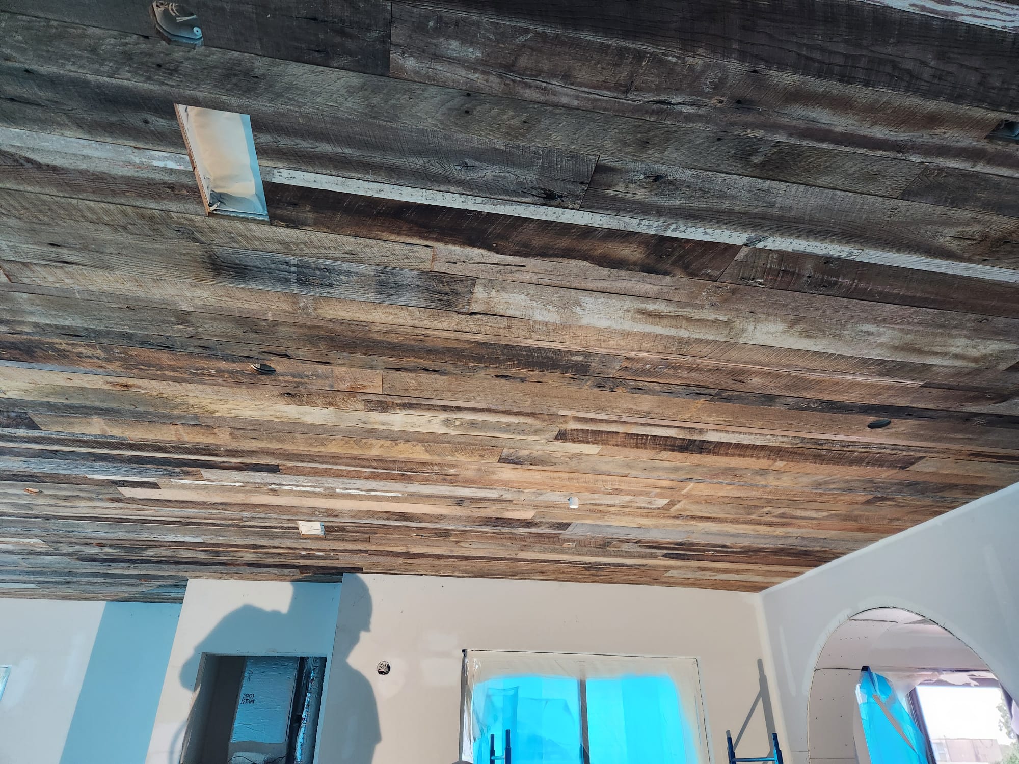 Full room reclaimed timber plank ceiling installation with cased archway in Lewisville NC