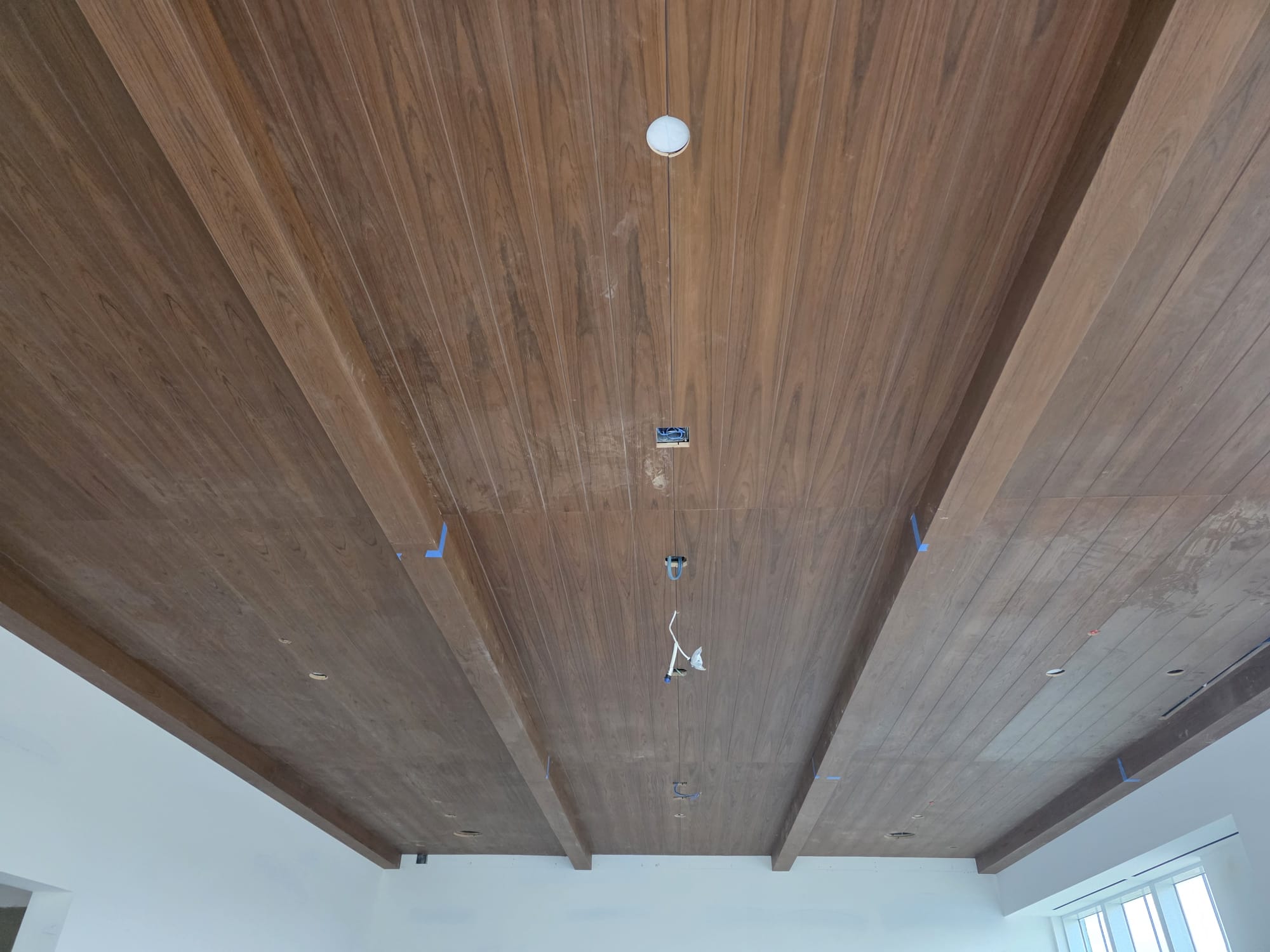 Stained walnut tongue and groove ceiling planks with running parallel timber box beams in Clemmons NC