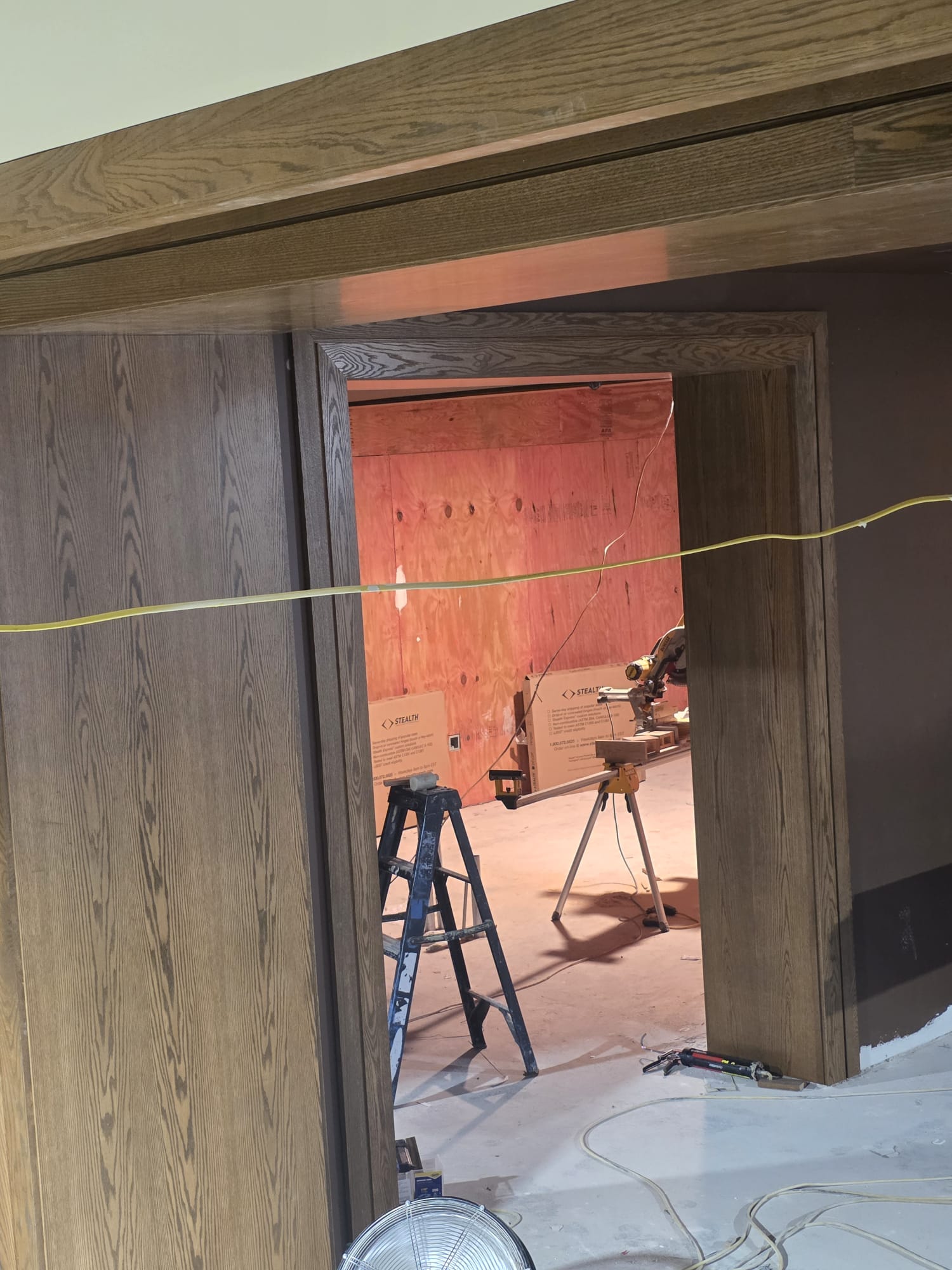 Stained oak cased doorway portal and full-height wood wall paneling under construction in Winston-Salem NC