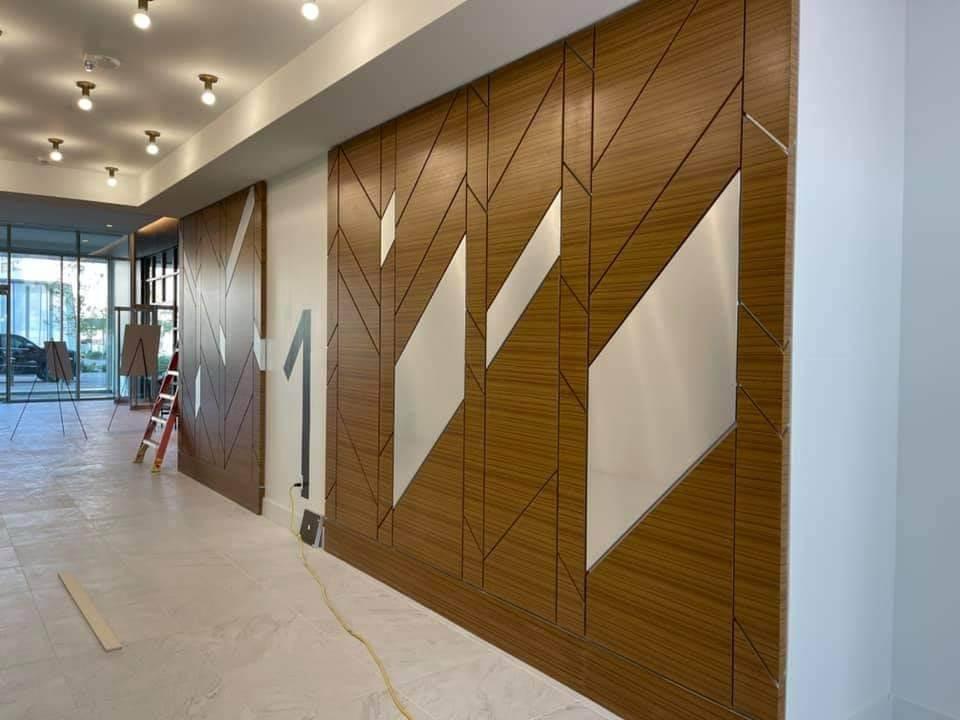 Geometric architectural wood veneer wall panels with brushed aluminum metallic angular inlays in Greensboro NC