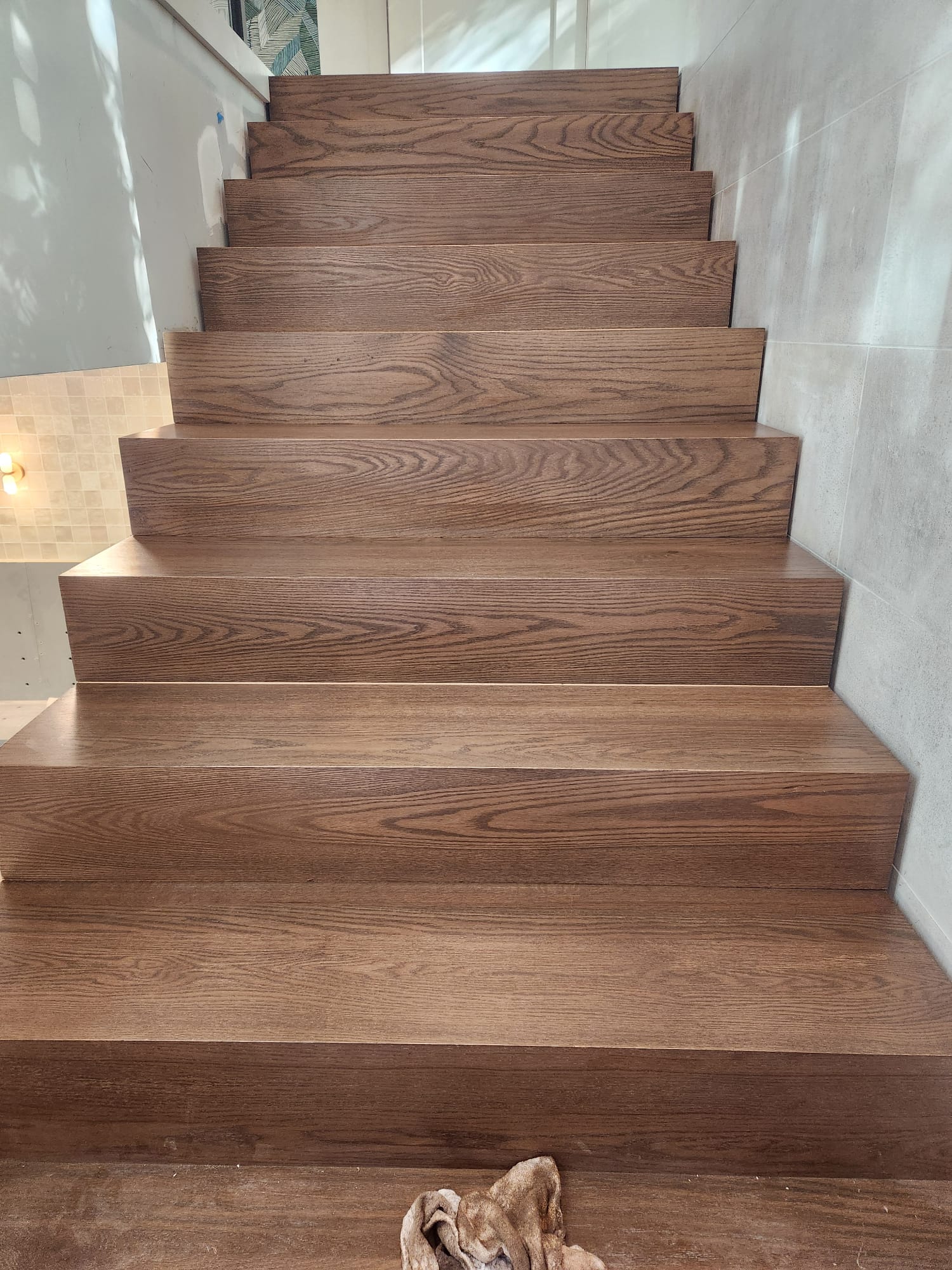 Custom dark stained solid oak closed-stringer staircase with continuous wood grain in Lewisville NC